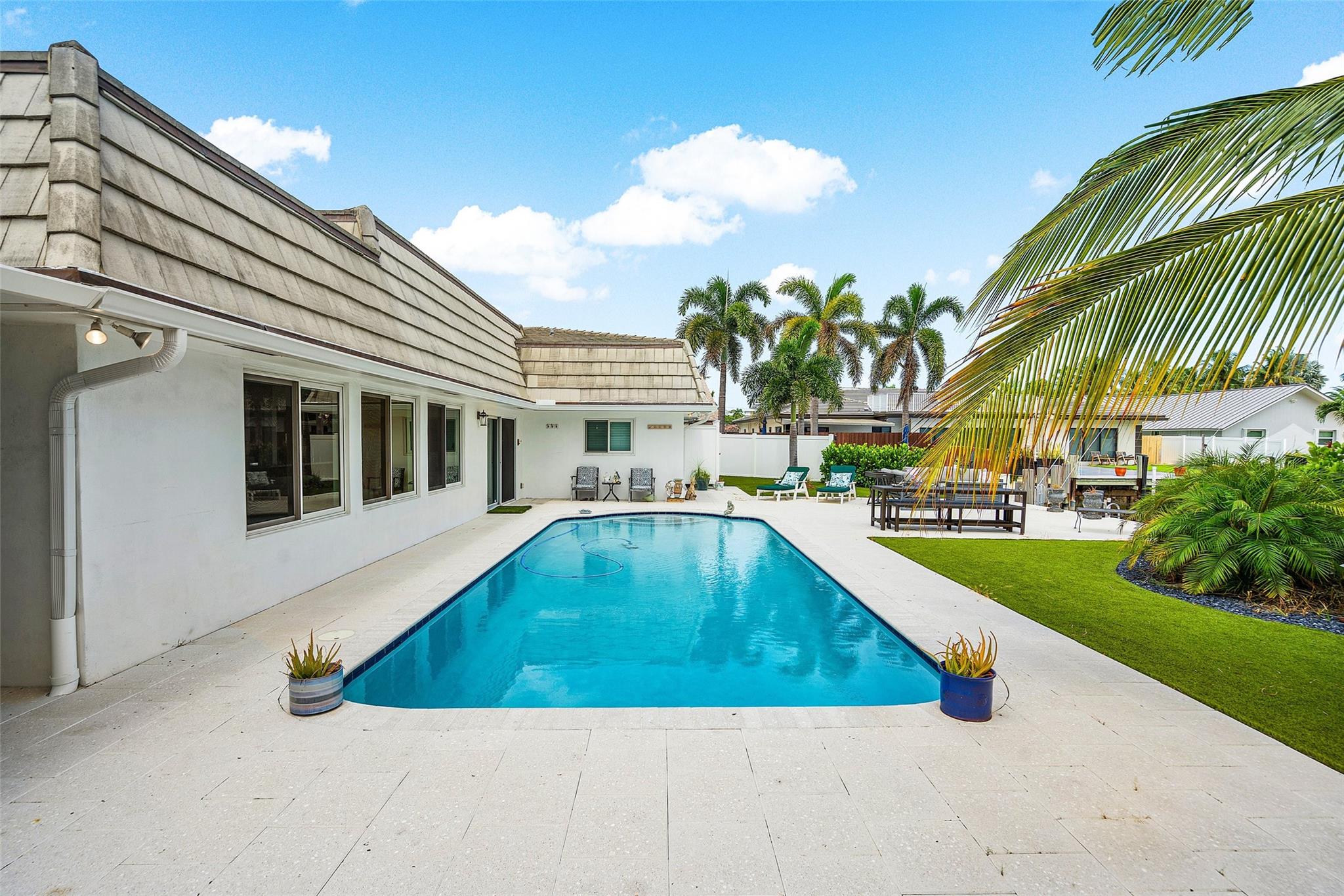 Experience the best of Fort Lauderdale living in this elegant waterfront residence offering a beautiful deep water canal view in coveted Coral Ridge! This 4-bed/3-bath home provides a bright, open layout w/an oversized backyard ideal for celebrating life's moments with friends & loved ones. The gourmet kitchen, spacious primary suite, & three separate living areas create a sophisticated yet relaxed atmosphere where everyone can have their own unique space. A generous patio surrounds the pool & dock with direct ocean-access; ideal for boaters or soaking in quiet morning sunrises. Offered fully furnished for immediate enjoyment or unfurnished to tailor to your lifestyle. Minutes to beaches, fine dining, & top-rated schools, this is the perfect blend of coastal luxury & everyday convenience.