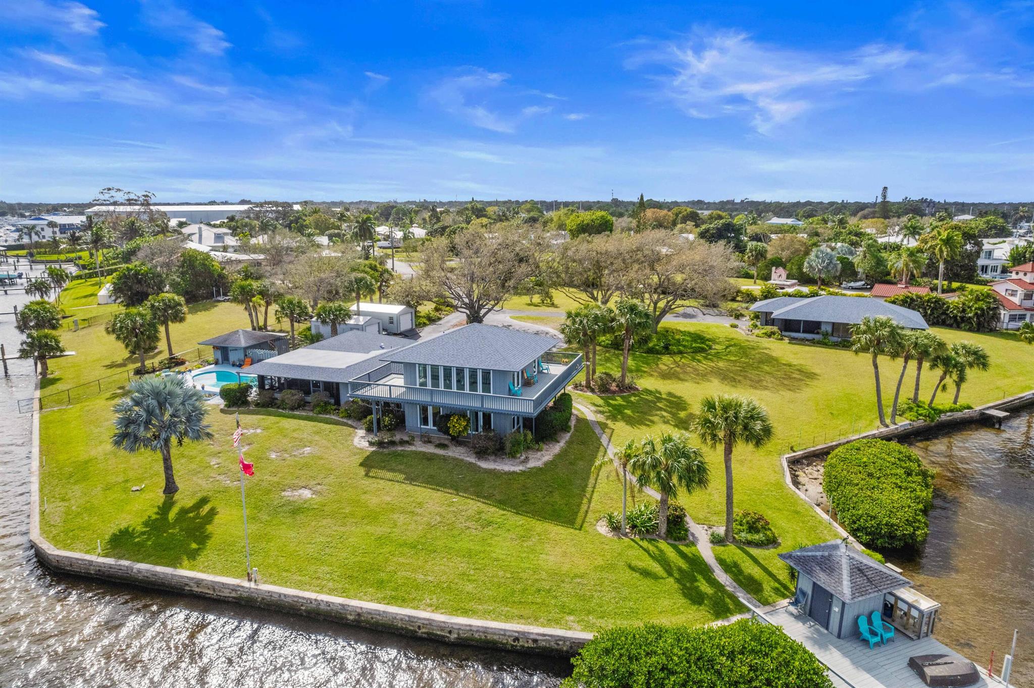 PROPERTY CAN BE SPLIT! 1.75 acres on the Manatee Pocket! Looking for ocean access and land? This Private haven is for the boating enthusiast who wants deepwater, with a 530 ft concrete seawall, wood dock w/ electric & water, dockage for four boats, a hurricane-rated 10,000lb boat lift. The 3 bedroom/2 bath Main House has a State-of-the-Art kitchen with top-notch S/S appliances: Natural Gas Cooktop, Quartzite Counters, Double Wall Oven, 42'' Soft-Close Cabinetry. New plank tile on the first floor. Wrap-around balcony on the second floor and screened patio provides additional entertaining space and amazing property and water views. Heated Pool. The 979 SqFt Guest House provides ample space for family and friends, w/ 2 Bedrooms, 1 Bath, 1 car garage. Roofs 2023, Impact Windows and more!