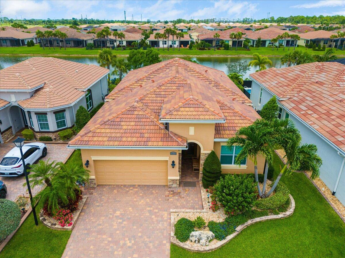 Beautiful Lago Model at Verano (PGA Village) with mature landscaping & lake View. Features CBS Construction, Barrel tile roof, paver driveway & walkway. Boasts open floor plan, volume ceilings, tile that looks like wood planking throughout, crown molding, Plantation Shutters & Impact Hurricane windows & doors. Hosts 2 BR's, Den, 2 BA's & 2 Car Garage. Fabulous open kitchen with quartz counter tops, glass back splash, large Island, light soft close 42'' cabinets, walk in pantry w/ wood shelves, wall oven, microwave, cook top, Stainless steel appliances & hood. Spacious Master Suite with natural lighting, tray ceiling, lovely Master Bath includes large shower & dual sinks. Walk in closet with wood shelves. Screen enclosed lanai with covered area & tranquil lake setting.