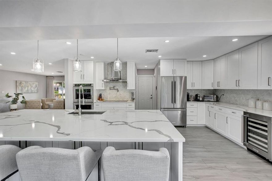 Wow... Contemporary, Coastal, Casual Elegance describes this amazing home completely reimagined, repurposed, and remodeled inside & out! Located in the highly desirable private city of Lighthouse Point across from multimillion dollar waterfront homes, this true 4-bedroom pool home features all the must haves for today's most discerning buyer.  Situated on an oversized corner lot in the sought after subdivision of Venetian Isles this home was completely redesigned in 2019 with meticulous attention to detail and superior craftsmanship with no expense spared. An open floor plan that boasts high impact windows & doors, high end wood plank ceramic floors, all new recessed lighting, 2 new sleek modern bathrooms, brand new gourmet kitchen with a 10' quartz island with ample seating & storage, and a new custom walk-in pantry, a spacious laundry room with new cabinetry, 8' solid wood paneled modern doors throughout, new dual HVAC system, heated saltwater pool and hot tub, an expansive and very private lanai with new travertine tile, and newly fenced for privacy with all new landscaping and outdoor lighting.