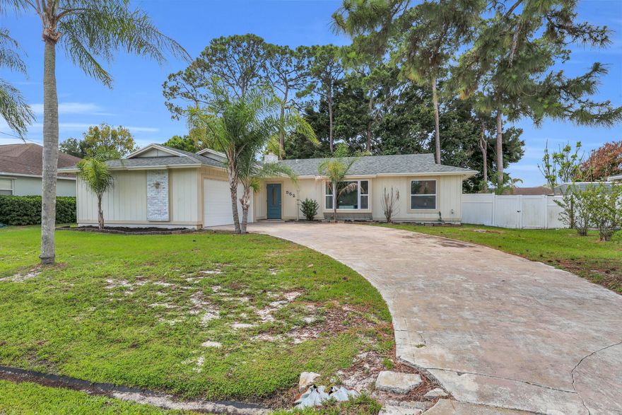 Beautifully updated 3BR/2BA home featuring a spacious open floor plan and modern finishes throughout! Completely remodeled in 2022, this move-in ready property also features a 2022 roof, 2022 HVAC system, impact glass windows throughout, and a hurricane-rated garage door for added peace of mind. Interior highlights include oversized porcelain tile flooring, a remodeled kitchen with large center island, white shaker cabinetry, stainless steel appliances, and abundant counter space perfect for entertaining. Split bedroom layout provides privacy, while the bright living and dining areas create an inviting atmosphere. Additional features include a 2-car garage with an air-conditioned workshop, a covered patio, a fully fenced backyard, a walk-in closet, and a wood-burning fireplace.