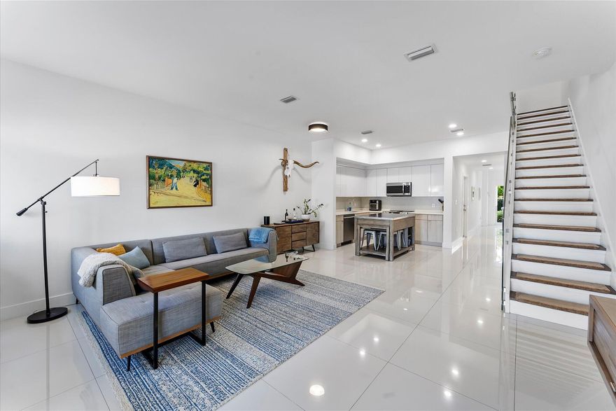Built in 2021, this contemporary 2BR/2.5BA townhouse with loft and attached one-car garage offers modern, low-maintenance living in an intimate 6-unit fee-simple community. Filled with natural light, it features hurricane-impact windows and doors, customizable Hue smart recessed lighting with app/Alexa control, large-format tile flooring, 9-ft ceilings, and a striking open staircase with glass railing. Upstairs, vaulted ceilings enhance the spacious loft, ideal for an office, den, or media area. Additional highlights include a full-size washer/dryer, charming courtyard entry, generous guest parking, and low HOA fees. Ideally located near the Oakland Park Culinary & Arts District, Wilton Manors, Fort Lauderdale beaches, shopping, dining, and FLL Airport.
