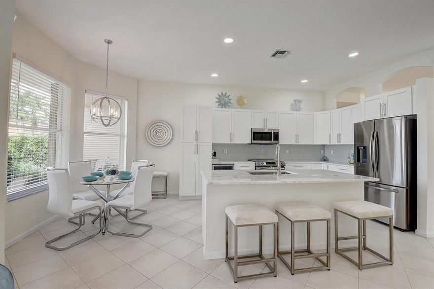 Move right into this stunning, newly renovated home that looks like a model home. No home like it. No popcorn ceilings. New window treatments. New elegant lights. New gorgeous kitchen with beautiful island with room for 3-4 stool in the front and possibly 2 stools on the sides. Range with front controls. Large pantry. Dual garbage and recycling cabinet. New Frigidaire beverage/wine cooler conveniently located near the center island and eating area. Elegant Quartzite countertops with pop up phone/computer charging tower. Wide plank, waterproof, pet proof, Shaw floors in bedrooms. Soft white uplifting Sherwin Williams paint throughout. Unlike other 3/2 models, there are European style sliding barn doors on the den/bedroom and newly built custom built closet to hang apparel. Primary bathroom toilet has a door for privacy. Both showers have dual shower heads and frameless shower doors. Accordion storm shutters. Many more renovation details. Sit on the covered patio and enjoy the tranquil, peaceful lake views with birds and ducks. HOA includes the clubhouse with many luxury amenities. Delicious café to dine inside or outdoors by the lake. Lucky you to live in this unique gem. Pet friendly.