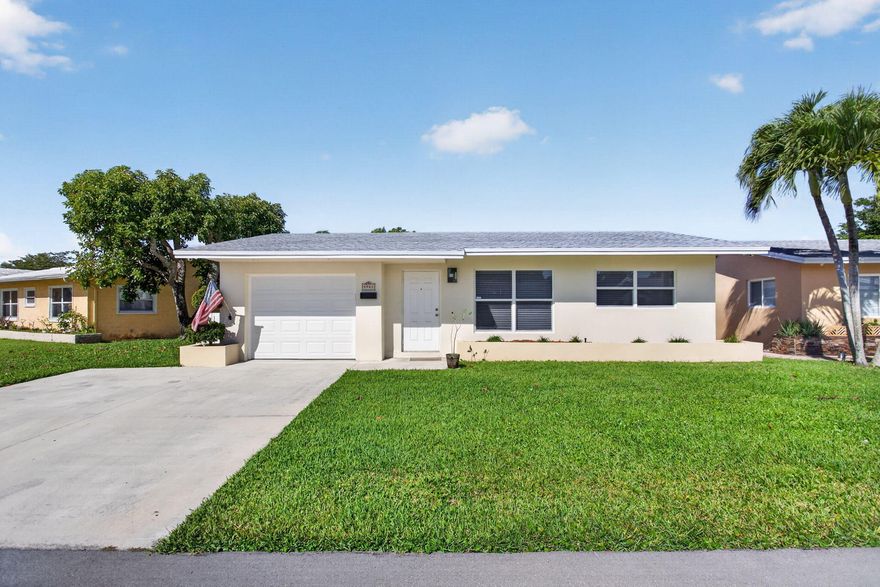 Tucked away on a quiet cul-de-sac in Mainlands of Tamarac Lakes, this beautifully maintained 2BR/1BA home captures the best of relaxed South Florida living with serene lake views and a covered, tiled patio perfect for morning coffee or evening sunsets. Inside, you'll find new wood-look tile flooring throughout the main living areas, granite countertops, white cabinetry, and stainless steel appliances creating a bright, modern feel. Major upgrades include a 2024 roof, impact windows, doors & garage door (except one small bathroom window), generator switch-ready setup, private irrigation system, and 2017 water heater. Low HOA. All ages & pet friendly community conveniently located near shopping, dining, and major roadways.