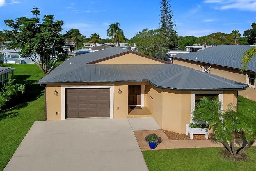 Move in ready.  Solid CBS construction with metal roof, storm shutters and permitted backup generator system.  This property has one of the lowest land lease payments for a new buyer at $409.93 (see attached).  Spacious split floorplan with ceramic tile throughout.  Custom wood kitchen cabinets, granite tops and stainless steel appliances.  Vaulted ceilings, spacious bedrooms and bathrooms, interior laundry room, one car garage, new water heater and large rear screened porch.  Spanish Lakes requires one adult over 55.  Land lease payment includes full access to all of the private community features; golf course, tennis, heated pool/spa, bocce ball, pickle-ball, shuffle board, clubhouse, fitness, and more.  Lawn care and trash removal is included. See attached.