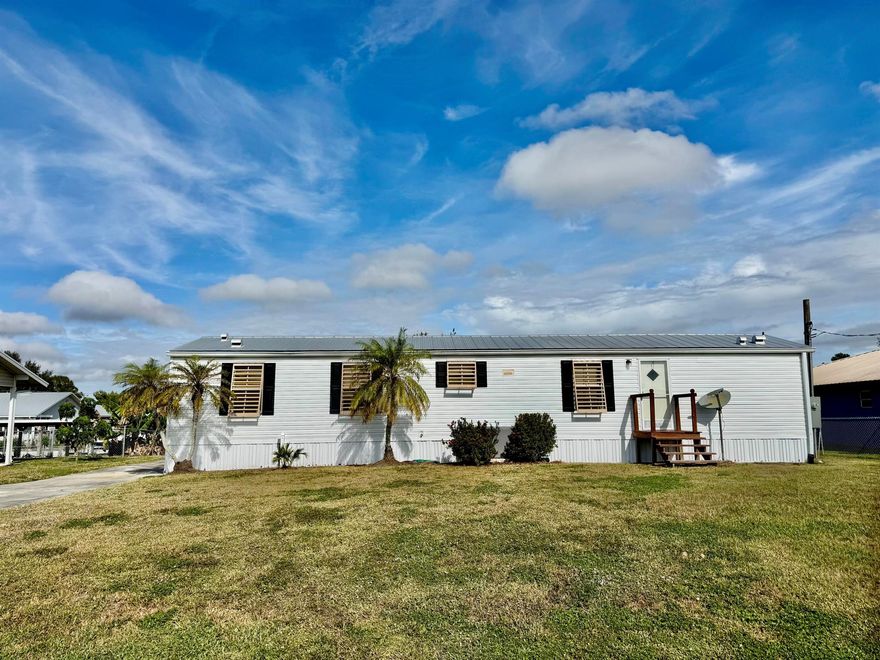 TAYLOR CREEK ISLES~ LAKE ''O'' Access.  Delightful 2005 SWMH. 2 Bd/2 Ba, 12x29 screened back porch. Split floor plan. Bright and cheery and full of charm. Metal roof, 10x16 and 11x11 storage sheds. Concrete seawall. Driveway is long enough for boats and cars - even a RV! Fully furnished and ready to be your FLORIDA GET-A-WAY! Dimensions are approximate, must measure for exact