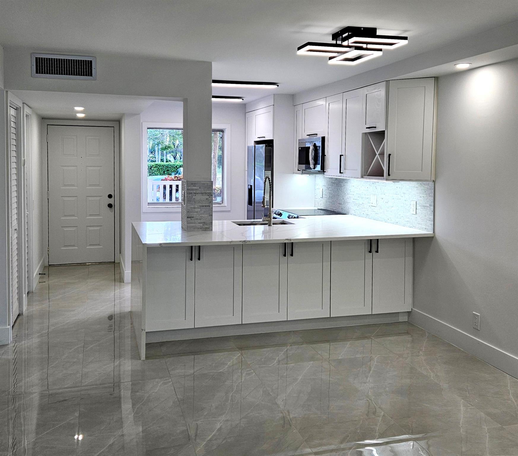 EVERYTHING NEW! This exquisite 55+ Huntington Lakes 1st-floor unit has undergone a FULL remodel. The kitchen boasts beautiful European framed shaker cabinets, Carrera quartz counters with waterfall, top-of-the-line stainless steel appliances with convection and air-fry oven, as well as custom under-cabinet lighting. Magnificent 24'' x 48'' imported porcelain tile reflects many of the modern lighting fixtures throughout the spacious living room, dining area, and bedrooms. Every detail has been carefully curated, ensuring a modern and sophisticated ambiance including a seamless flow into both bathrooms featuring designer touches. All new smooth ceilings. Relax on your serene private patio. Reserved parking spot directly in front. NEW AC, WATER HEATER as well as NEW CLUBHOUSE. Welcome home!