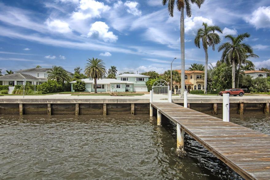 Rare Waterfront home on S. Flagler with Dock including  water and electric across the wide Deep water area of the intracoastal  from Maralago.  4770 Square feet with a large saltwater chlorinated pool on an almost 13k square foot lot.   3 Bedrooms and 3 bathrooms and a second floor 2 room master suite with showered bath and separate stairs on the deck down to the pool area.  Large screened in patio, 2 car garage and separate laundry area with work space.  House can be largely renovated and expanded.  Elevation is almost 7 ft.