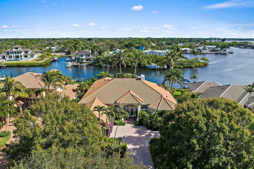 Nestled within the prestigious community of Islands of Jupiter, 18829 SE Windward Island Lane is a waterfront oasis offering unparalleled luxury and comfort. This exquisite residence spans 4,193sq ft of living space with a total of 5,813sq ft, featuring 4 bedrooms, 3 full baths, and 1 half bath, as well as an office/den and a 2-car A/C garage. Situated on an expansive .43-acre lot along the serene Loxahatchee River, this home is a boater's dream, boasting a private dock equipped with two boat lifts one 16,000lb lift, and the other is a 12,000lb lift. Additionally, a dual float-on jet ski dock adds to the waterfront allure. The outdoor living space is a true haven, featuring a heated pool and spa. An outdoor kitchen, complete with a grill, sink, ice maker, & beverage center, SEE MORE...