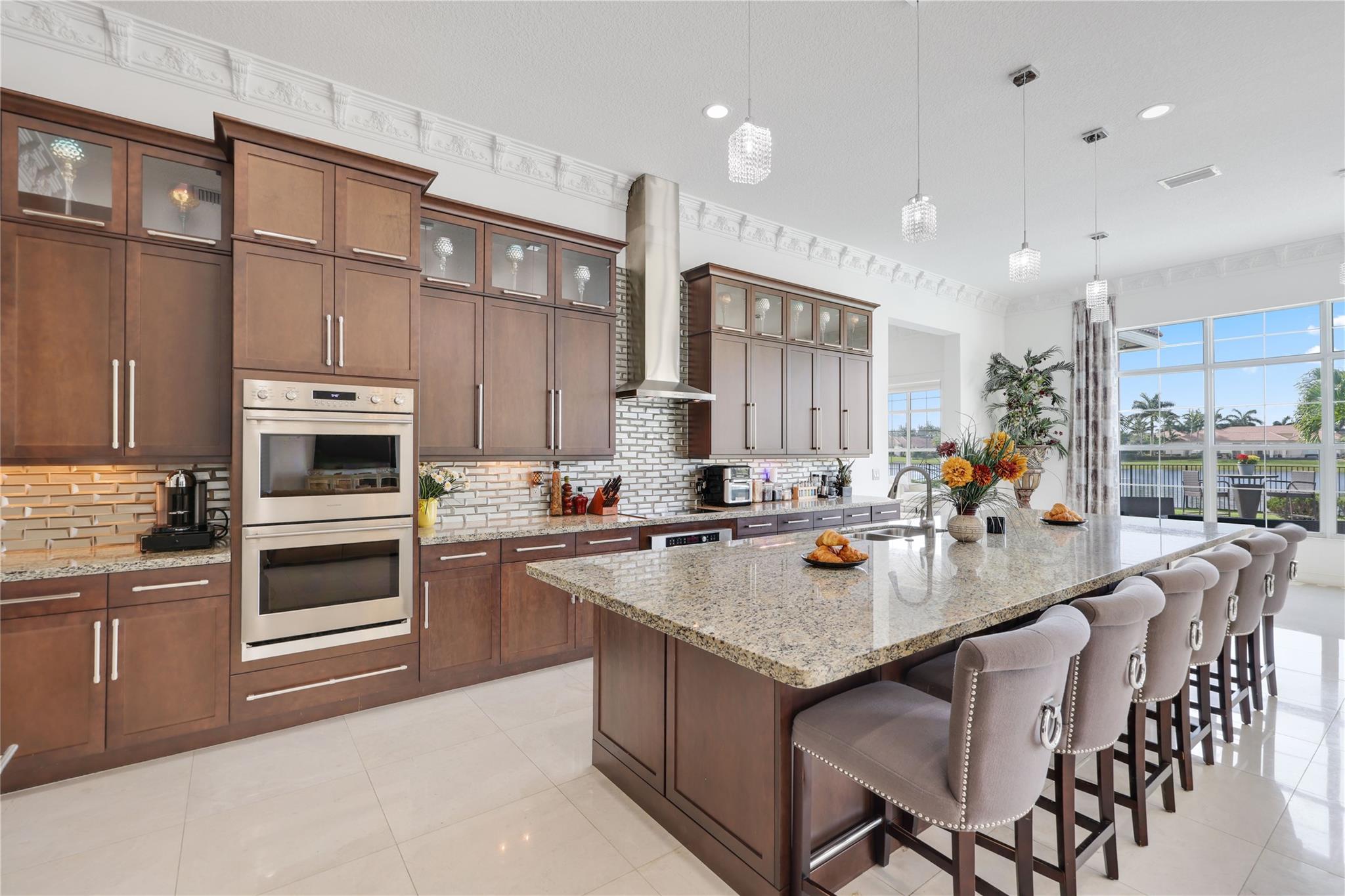 Masterfully reimagined & crafted for luxurious living, this 4-bed | 4-bath estate in the prestigious gated enclave of Sterling Ranch embodies modern elegance at every turn. Nestled on a sprawling homesite, this custom residence showcases soaring ceilings, expansive open-concept living, and curated finishes. The gourmet kitchen boasts a grand quartz island, premium self-cooking Sub-Zero & Monogram appliances, double ovens, and an oversized walk-in pantry. Retreat to a spa-like primary suite with dual walk-in closets, a freestanding soaking tub, & his-and-her shower. Impact windows & doors, plus a 3-car garage, complete the package. Enjoy a solar-heated Salt water pool & lush yard with mango, lemon, and cherry trees. Minutes from top-rated schools, shopping, dining, and the Hard Rock Hotel.