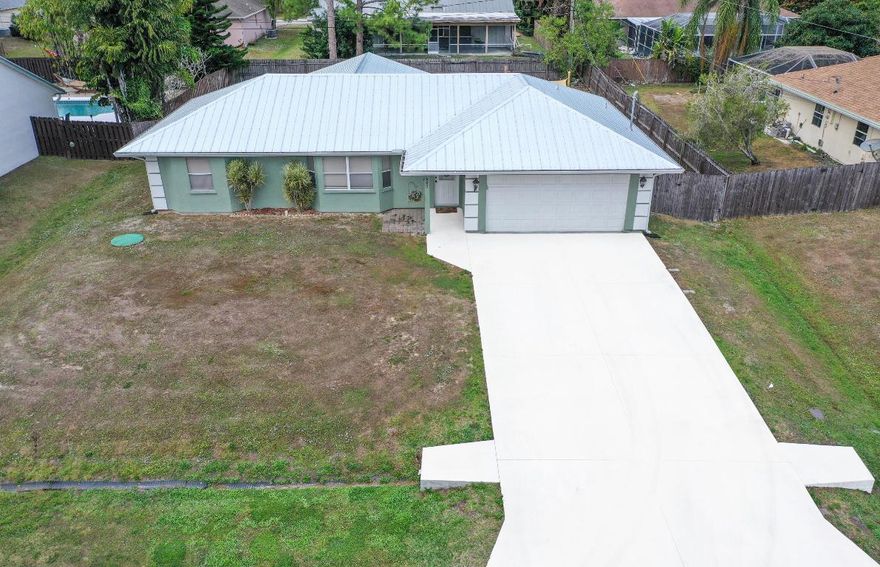 Beautiful Port Saint Lucie home in a great location. 3/2/2 split floor plan, vaulted ceilings, and tile throughout. Large garage and large porch area with a great fenced back yard. Stainless steel appliances 2022, NEW ROOF 11/24, Oversized Driveway repaved 1/25, AC 10/23. Dont miss out on this beautiful home!