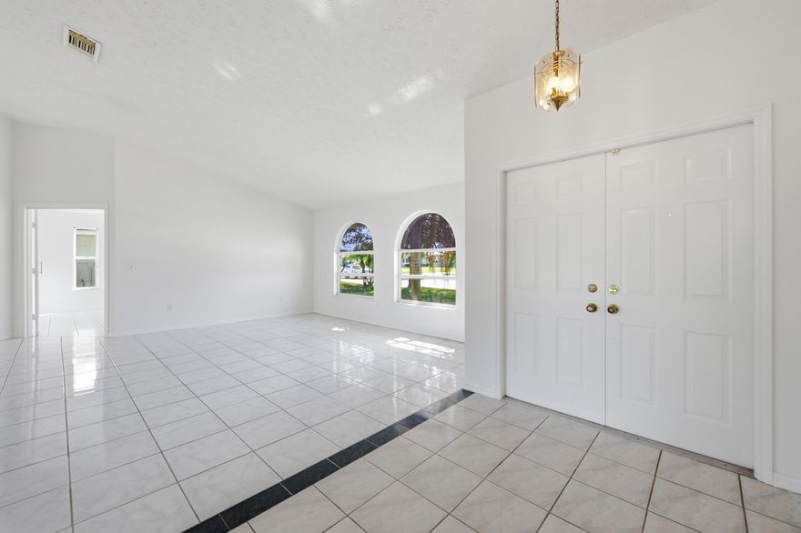 Step through the grand double-door entry and into a home that instantly feels open, bright, and welcoming. With nearly 2,000 square feet of living space, this spacious 3-bedroom, 2-bath, 2 car garage home offers a great balance of comfort and room to grow.  Recent updates bring peace of mind and modern appeal, including a brand-new roof (2024), freshly painted interior, updated guest bathroom, and stylish new flooring in the guest bedrooms. The spacious primary suite serves as your private retreat, complete with a soaking tub and separate shower—perfect for unwinding at the end of the day.  Out back, enjoy a covered, screened-in patio that's ideal for relaxing or entertaining, overlooking a generously sized yard with plenty of possibilities. Separate laundry room conveniently located next to the garage.  Enjoy the freedom of no HOA, and being centrally located where you'll have easy access to the Turnpike, US-1, and I-95—making commuting a breeze. You're also just minutes from popular dining, shopping, parks, and schools, and less than 30 minutes from the beach.