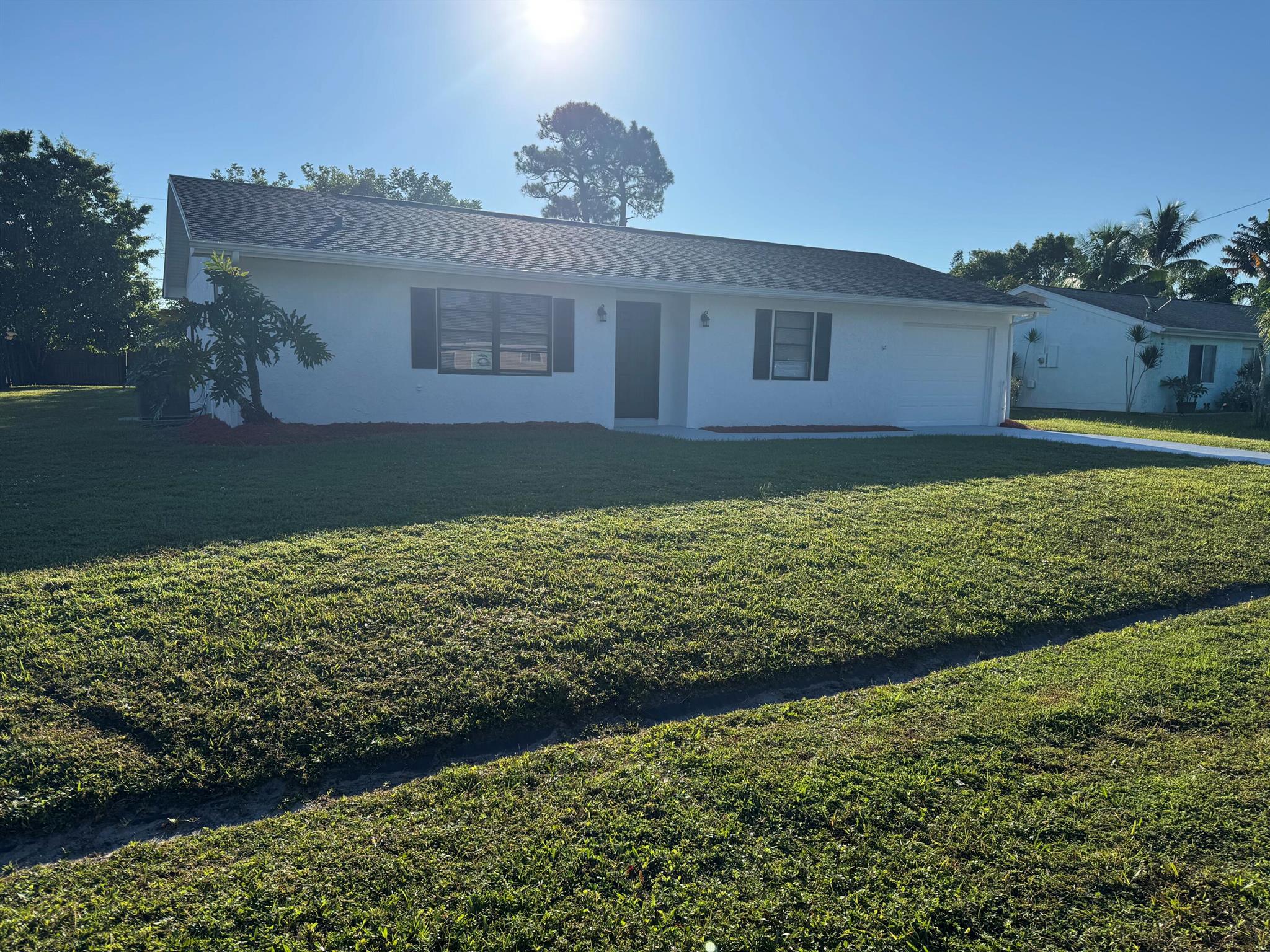 Outstanding location! RV/Camper/Boat welcome! East of Port Saint Lucie! Close to Jensen Beach, medical offices/hospital, beaches, restaurants, shopping and PSL West! Just off Port Saint Lucie Blvd., and minutes away from the Turnpike, Crosstown, I-95 - all nearby! Come see this 2/2/1 completely remodeled from top to bottom home! It comes with a newer roof. It also comes with brand new white shaker 36'' cabinets and gorgeous quartz countertops/backsplash and newer stainless steel appliances. It also has brand new waterproof luxury vinyl planks/laminate flooring and elegant baseboards, brand new vanities with quartz countertops, beautiful tile in both bathrooms, water/lighting fixtures throughout the whole house, new ceiling fans,