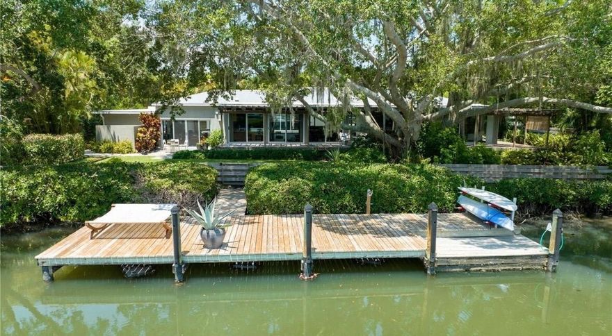 Waterfront Pool Home with Private Dock and Beach Access.  Conveniently located on the North side of Siesta Key and completely updated by Pat Ball Construction. This property contains a 2 bedroom/ 2 bath Main House, with open floor plan, custom solid cherry wood kitchen cabinets, stainless steel counters and appliances, Bonus workout room/office and 2 car tandem garage parking. The Spacious Primary Suite, has views of the water, large custom walk in closet, primary bath with walk in shower, separate large whirlpool style tub and plenty of storage. The living room has panoramic water views, TV viewing area, and custom cabinetry. The guest bedroom overlooks the pool area and has full bath with walk in shower. The Guest House: Contains 1 bedroom /1 bath, large living area, Kitchenette with