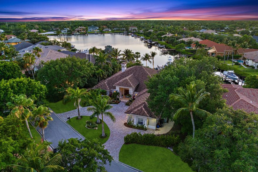 A boater's and entertainer's dream! Experience waterfront luxury living with over 100 feet of Loxahatchee River waterfront! This stunning 4,336 sq ft home, situated on .68 acres, is dramatically updated inside and out. Open the front door into an expansive living room, overlooking a beautiful outdoor living area, complete with a custom pool/spa, expanded outdoor kitchen, turfed yard and putting green, and a recently rebuilt dock complete with a 40k lb lift. The primary suite features a split bathroom, whirlpool tub and sauna, and newly built out dual walk-in closets. With an updated kitchen, 2020 roof, refreshed guest rooms, and brand new beautiful climate controlled wine storage, this home truly has it all. Ocean/restaurants just a short boat ride away.