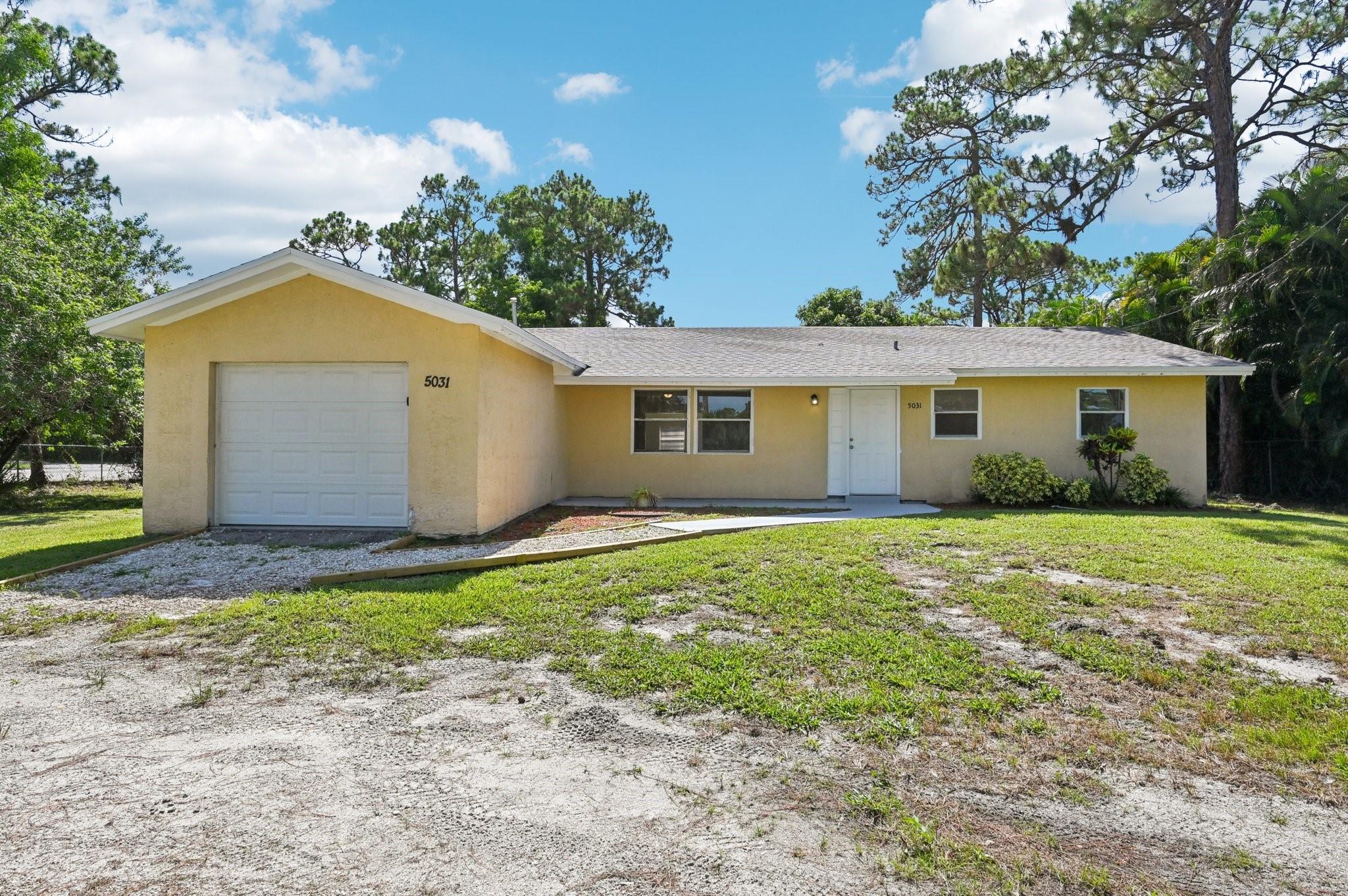 Tucked behind a canopy of mature pines and lush tropical foliage, this beautiful 3-bedroom, 2.5-bath home in Royal Palm Beach offers privacy and serenity on a spacious lot! A gated entrance opens to a peaceful front yard with a park-like feel, while the home sits quietly set back from the road. Inside, enjoy a functional layout, and outside, a huge backyard provides endless possibilities for entertaining, gardening, or play. The property also includes a 1-car garage for added convenience. Ideally located near shops, dining, and local attractions, this hidden gem offers both convenience and room to grow and relax!