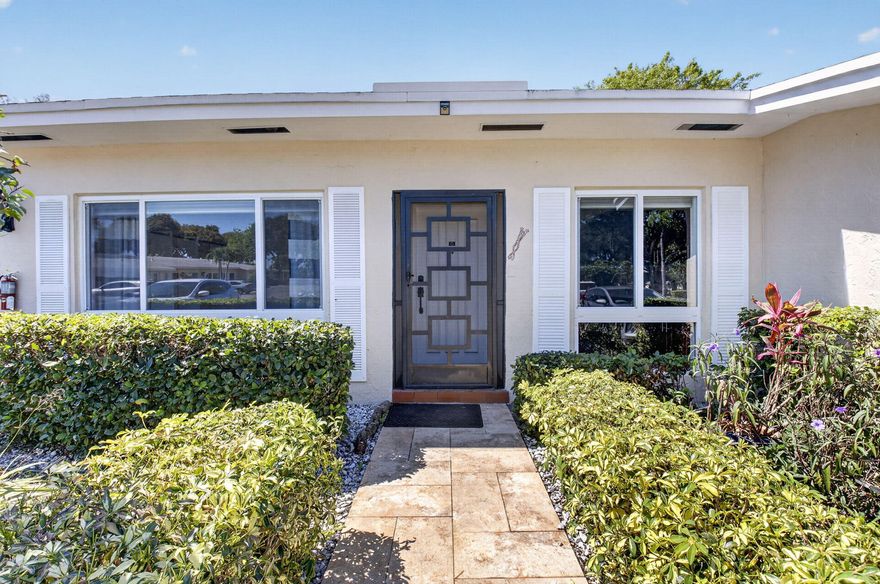 Beautifully updated 2-bedroom, 2-bath home featuring 24" porcelain tile throughout and tasteful custom details. The remodeled kitchen offers wood cabinetry, granite countertops, tumbled marble backsplash, and stainless steel appliances. Frosted glass interior doors add a modern designer feel.  The guest suite includes a private updated bath with vessel sink and rain shower, while the spacious primary suite features a dressing area, organized walk-in closet, and additional vanity sink. Crown molding and upgraded 6" baseboards complete the refined interior. All impact windows except patio slider   Relax in the screened patio with a serene garden view . Low monthly maintenance includes water, cable , clubhouse, tennis, fitness center, and a vibrant community l