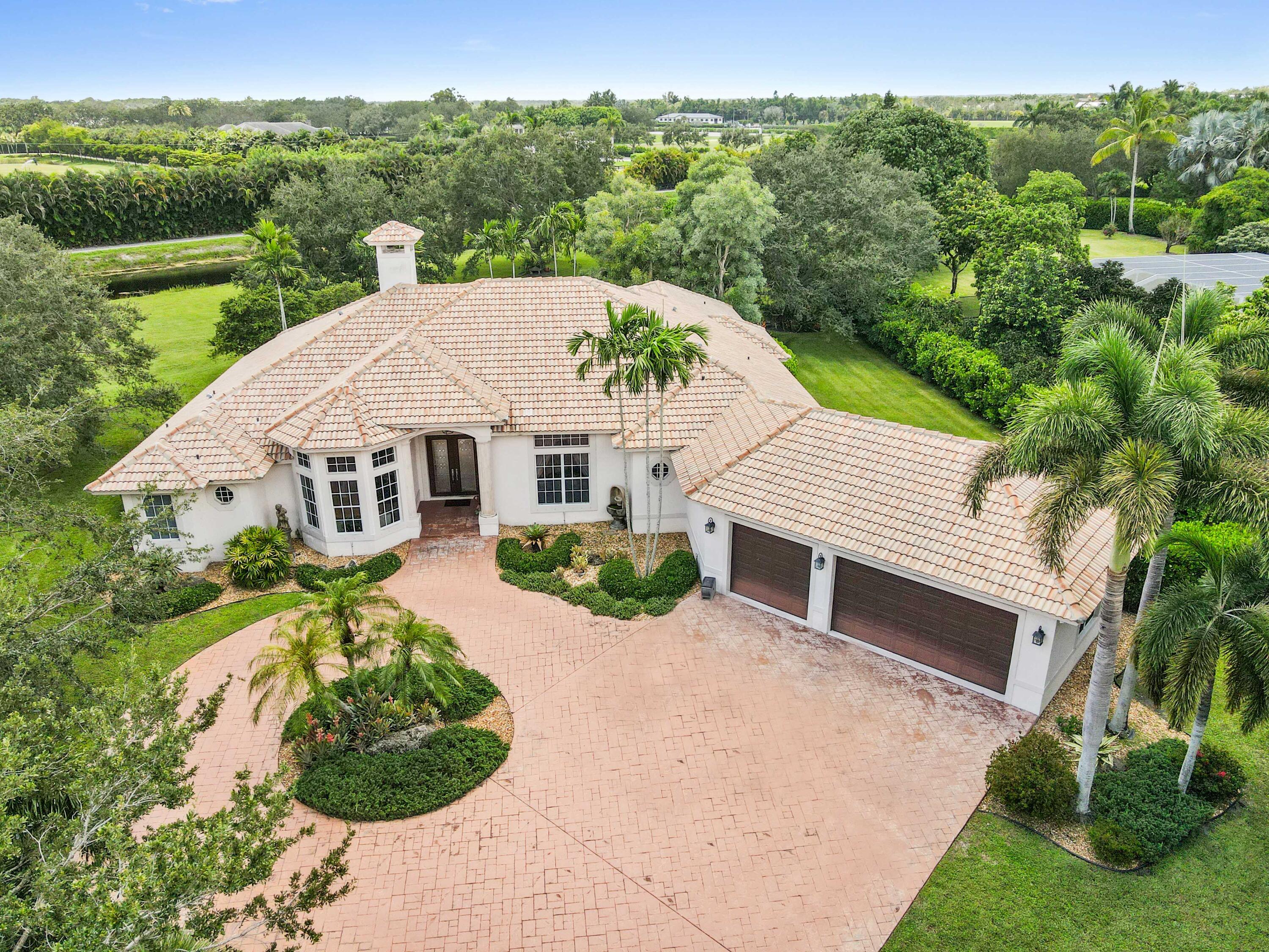 Prepare to be utterly captivated by this true estate home, a testament to luxurious living with an abundance of unique and exquisite features. This beautiful property is located in the prestigious Aero Club Community. A regal entrance is set by an extra-long circular driveway and a deep front yard, leading to one of the largest lots in The Aero community at 1.34 acres, boasting gorgeous pastoral and breathtaking sunset views. Designed for the ultimate Florida lifestyle, the property features two inviting patios, both screened and covered, alongside a heated pool and spa, all beautifully flanked by lush landscaping for optimal privacy and aesthetic appeal.