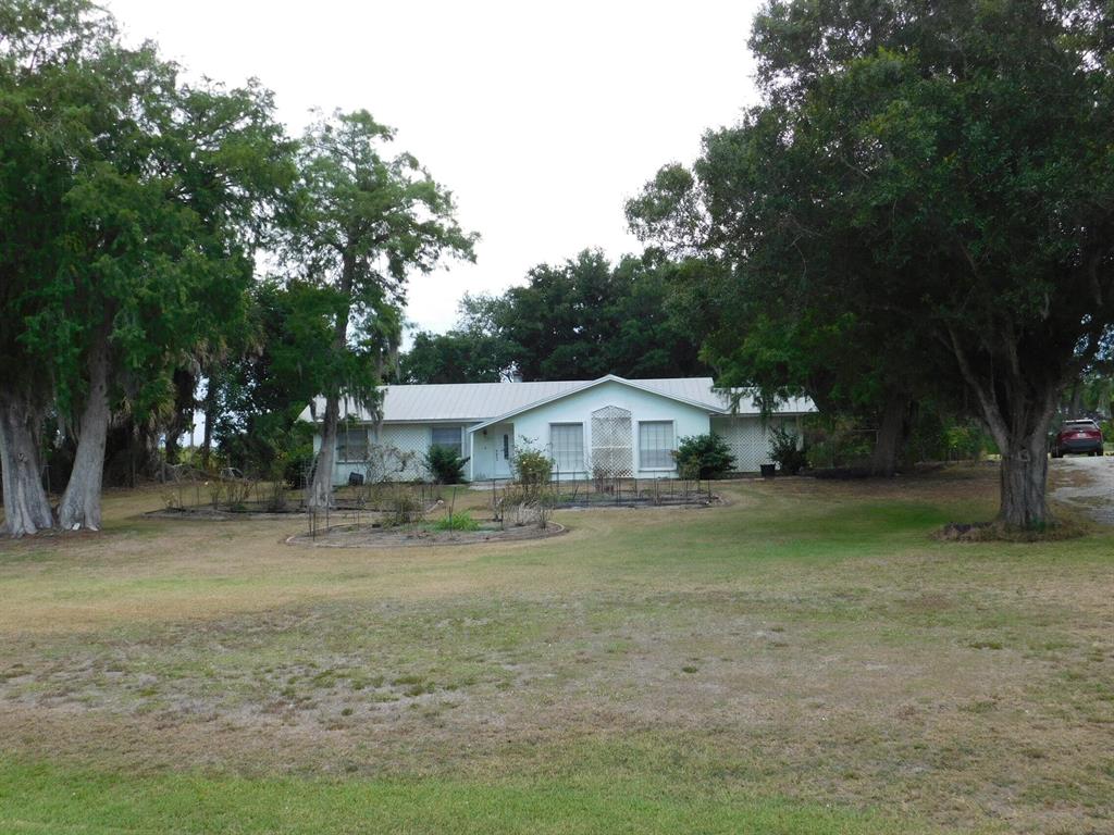 Rare opportunity! 3.39 acres provides privacy and plenty of room for hobbies or animals. The ranch style home features a metal roof installed in 2006, central air 2021, accordion shutters, fireplace, and kitchen remodeled in 2005. Nearby boat ramp gives boating access to Lake Okeechobee. The backyard has beautiful oak trees, mango and royal poinciana.