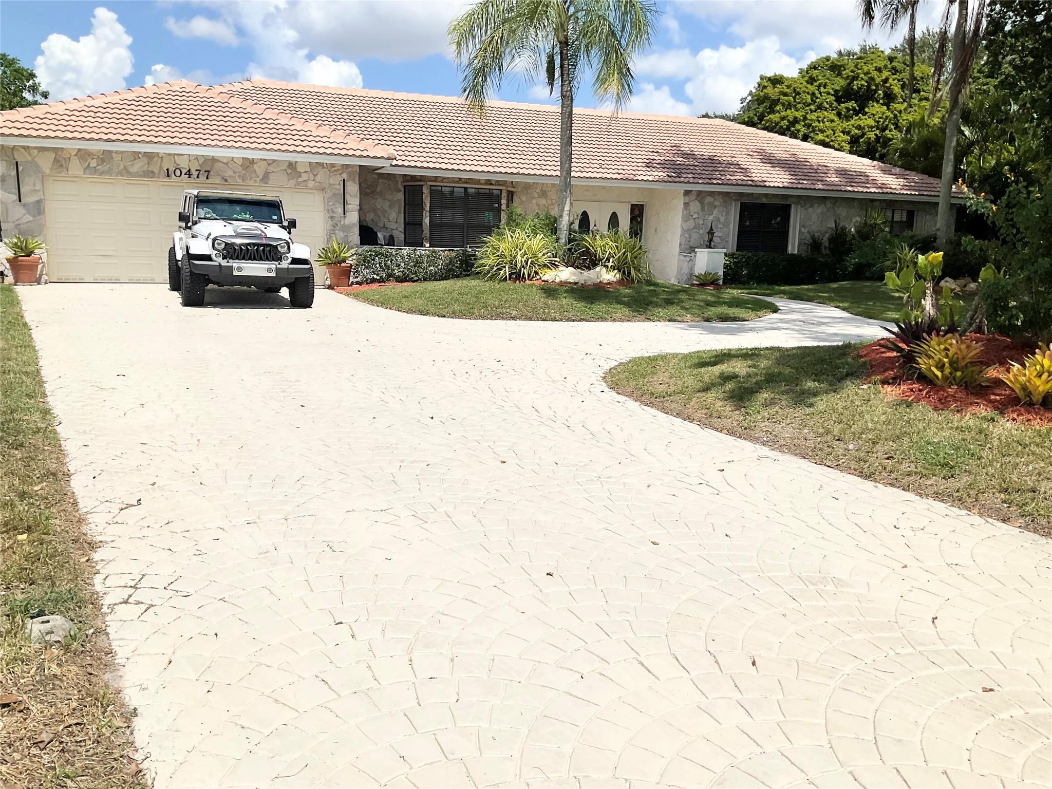 One of the largest homes in Coral Springs at just under 4000 sq ft, on nearly a half acre of land.
Exquisite 4 bedroom, 4 bathroom estate with sweeping driveway, sprawling lot & lush landscaping on peaceful cul-de-sac in the desirable neighborhood of 'The Oaks'. NO HOA.
This beautifully kept home features two spacious master suites, huge walk in closets, a cedar closet, new roof 2025, newer a/c's, new tile & a  gourmet kitchen with custom cabinetry, stainless appliances & waterfall granite countertops. The resort style backyard boasts an oversized diving pool, fountain, gazebo, large garden with deck and gorgeous sunset views. The outside bar and grill area features an open seating area to enjoy the lovely Florida evenings.