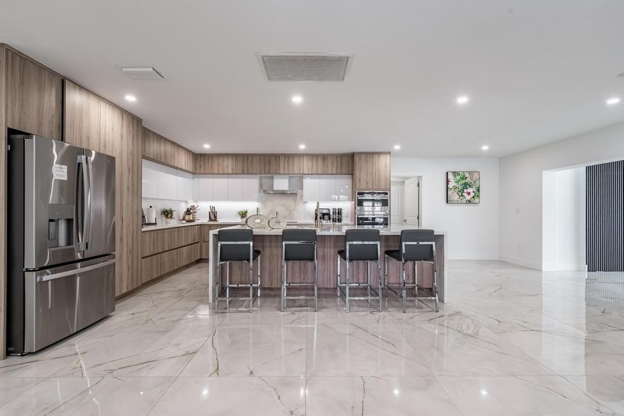 Experience uncompromising modern luxury in this fully reimagined residence, anchored by a show-stopping chef’s kitchen w/ waterfall quartz islands, custom cabinetry, expansive counters, & double wall ovens; perfect for entertaining in the elegant dining area with seating for 14+. This spectacular 5BR/3.5BA/5,498SF one-story estate is fully remodeled for style & comfort. A grand formal living room w/vaulted ceilings flows into a spacious family room, while new impact windows/doors open to a private, resort-style pool. Final touches include renovated baths & custom zebra shades for added privacy. A fully fenced/expansive backyard and new roof, add  practicality. Ideally located near Cutler Bay, Palmetto Bay & Pinecrest, w/highly rated schools, vibrant parks & shopping just minutes away.