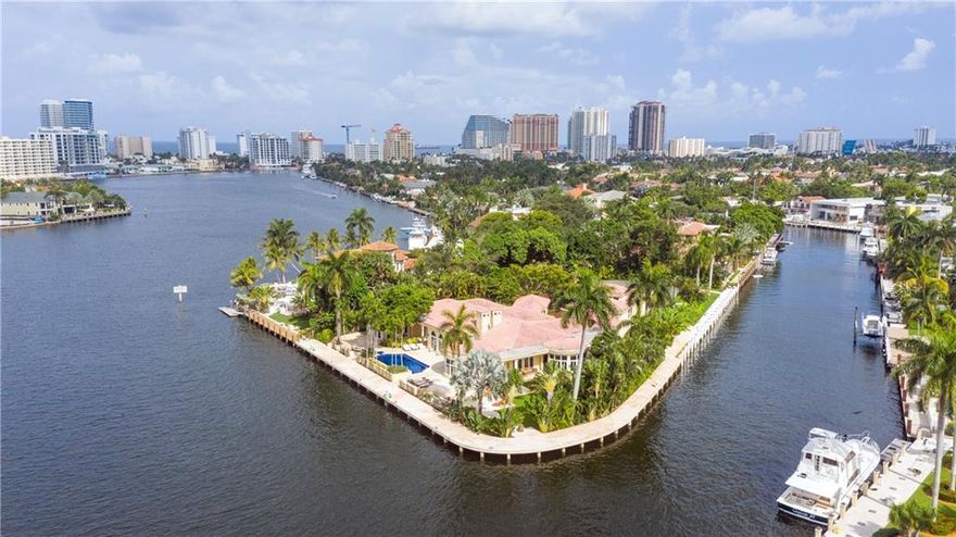 Super-Yacht Haven: Simply Unique. Nothing like this beautifully landscaped point lot in Las Olas. 550’ of deep protected waterfront on 1.14 secluded acres located on the most desired street in Las Olas and on the wide and tranquil Rio Barcelona, named by Ponce de Leon. Includes separate building lot with lighted tennis court. Gated entry with long driveway leads to circular covered entrance to the home. Almost 10,000 square feet of European style elegance. Soaring ceilings and large fireplace grace the great room and the warm family room with bar and billiards area. Outside is a semi-enclosed lounge and outdoor dining area overlooking the water and gardens. The kitchen is designed for a professional chef.  The huge first floor master suite and a private office open to the pool.