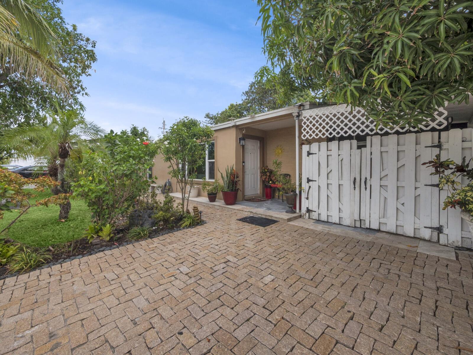 This 3-bed, 2.5-bath home offers versatile living with the possibility for extra income, featuring a private entrance and a second kitchen. The property includes a welcoming front yard and a fully fenced backyard designed for relaxation and entertaining. Enjoy a covered BBQ and grill area with a built-in grill and wood-burning oven, along with an above-ground pool, paver patio, fruit trees, and a storage shed. A screened porch with a convenient cabana half-bath adds comfort and easy access to the yard.2016 AC, Hurricane impact windows throughout most of the home, a sprinkler system, well pump for savings, and plenty of driveway parking. NO HOA! Conveniently located near shopping, dining, and just minutes from the beach!