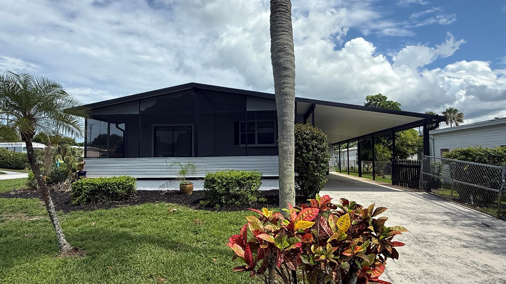 Much sought after CORNER Property in Section 1 of Cambridge where you can bring you Boat/RV. Large 2 Bedrm/2 Bath Manuf home in Cambridge, 55+ Community in Hobe Sound. Newer all wood Kitchen w Granite counters, stainless appliances, soft close drawers & pull up bar open to the dining area & Large LR. The LR opens up to the expansive Screen Room which stretches across the front of the home. The Perfect spot to enjoy the famous Hobe Sound Ocean Breezes & stunning sunsets while having Morning Coffee or Evening drinks. The oversized yard is partially fenced & irrigated by well. Cambridge is an active 55+comm w Clubhouse, heated pool, shuffleboard, billiards, exercise rm & a host of clubs & activities. Adjacent to Heritage Ridge Public Golf Course. YOU OWN THE LAND - ALL PETS WELCOME.