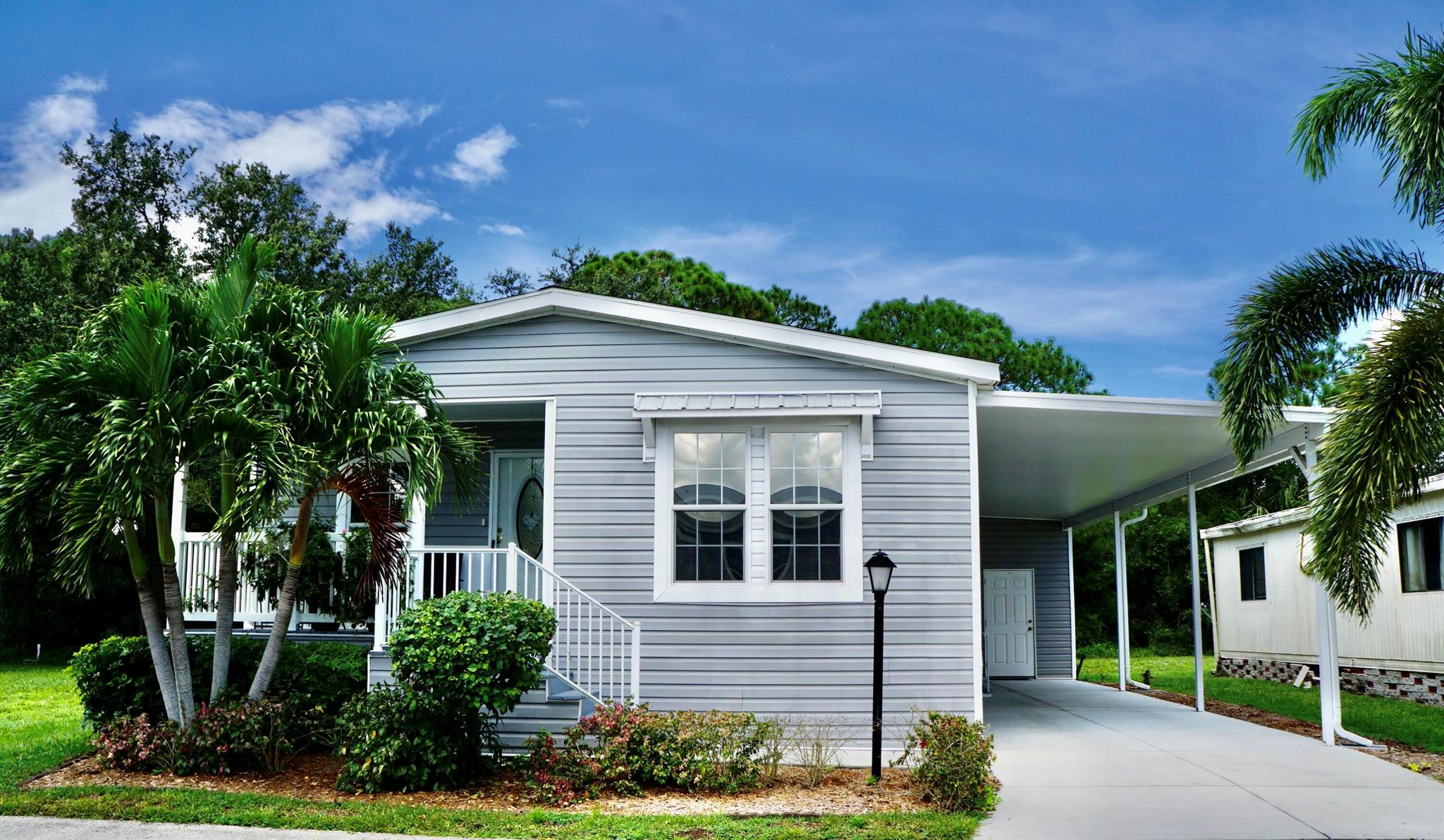 Shows like brand new--just 7 years old! This 2018 Fleetwood home features an open concept floor plan ideal for entertaining lots of friends & family. The large eat-in kitchen offers many cabinets and lots of counter space. This 3 bed/2 bath home offers a huge owner's suite w/ large closet and oversized bathroom. Modern recessed ceilings add to the beauty. Inside laundry for convenience. Enjoy a private backyard or relax on the welcoming front porch. Large attached carport and an 88 shed--perfect to store tools or pool floats. A perfect blend of comfort and functionality! The $923 monthly land lease covers lawn care and resort-style amenities: swimming, fitness center, tennis, shuffleboard, and more. Near beaches, restaurants, & shopping. Move in and embrace the Florida lifestyle today!
