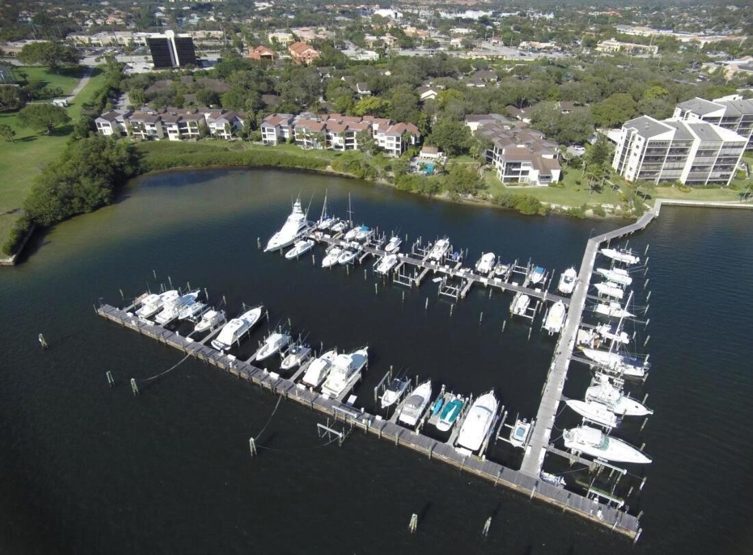 SEASONAL RENTAL with 50ft BOAT SLIP (no lift) Welcome to this beautifully updated and fully furnished 2-bedroom, 2-bathroom condo in Twelve Oaks! This spacious second-floor corner unit boasts an open floor plan with no carpet, stainless steel appliances, and a light and bright neutral decor. The added high hats and textured walls throughout add a touch of elegance to the space. One of the highlights of this condo is the huge balcony with glass doors and screens, providing extra indoor living space and stunning tree-top views. The community offers 24/7 gate-manned security, pools, and tennis courts, making it a perfect blend of comfort and convenience. Additionally, the rent includes up to $100 a month of electric, cable, WiFi, water, and trash, offering a hassle-free living experience.