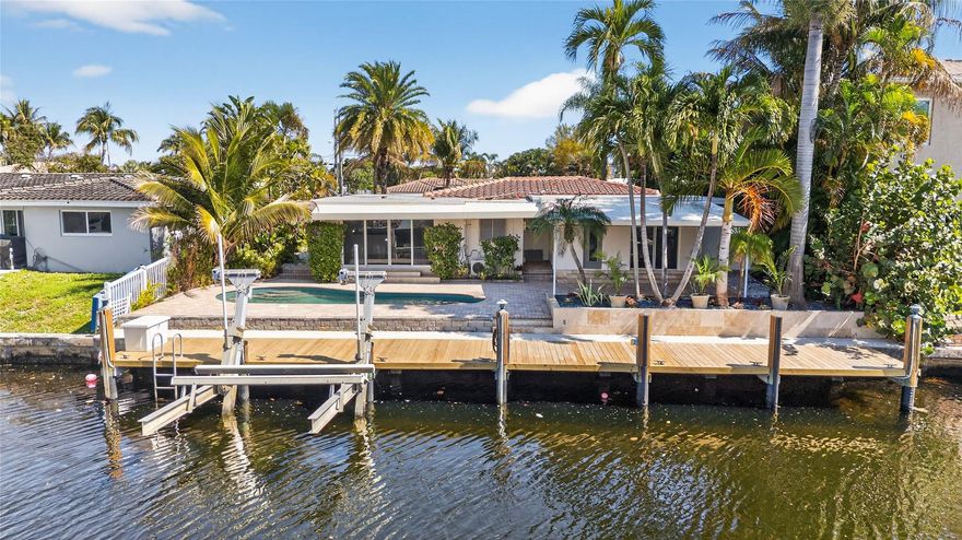 Welcome home to the beautiful boating community of Cypress Harbor! This home is in high demand with only 1 fixed bridge 12-15 ft clearance and a 10 minute boat ride to the intercoastal in Pompano Beach! When entering into your home, enjoy the open kitchen to living & dining room with a custom granite breakfast bar.  Traventine marble flooring accents the main living areas. New S-Tile roof (2025), landscaping, paint inside & out, carpeted bedrooms. Dock your boat at your private 60 dock or use the boatlift with a 13,500 lb lift. Splash in the pool or entertain in the evenings under the large canopy overlooking the ocean access canal. Hurricane impact windows & doors, pavers around the pool & front driveway, remodeled bathrooms & spacious walk-in closet in master bedroom.