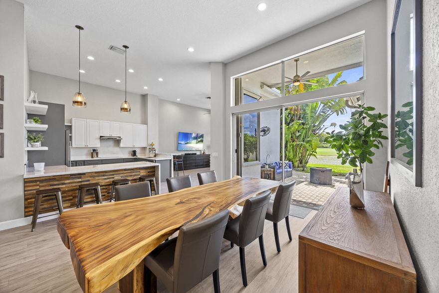 Experience luxury living in this stunningly renovated one-story home with 3 bedrooms, a private office, and 2.5 baths, perfectly positioned for sweeping lake and golf course views with breathtaking sunsets. Soaring ceilings and sleek wood-look porcelain tile create an airy, upscale feel. The showstopping kitchen features 42" white and gray cabinetry, quartz and marble waterfall countertops, stainless appliances, and a warm wood accent wall. French doors open to a private office, while spa-like bathrooms elevate daily living. The spacious primary suite offers custom closets and a true retreat feel. Enjoy peaceful evenings on the patio, where tranquil lake and golf course views create the perfect backdrop for unforgettable sunsets.
