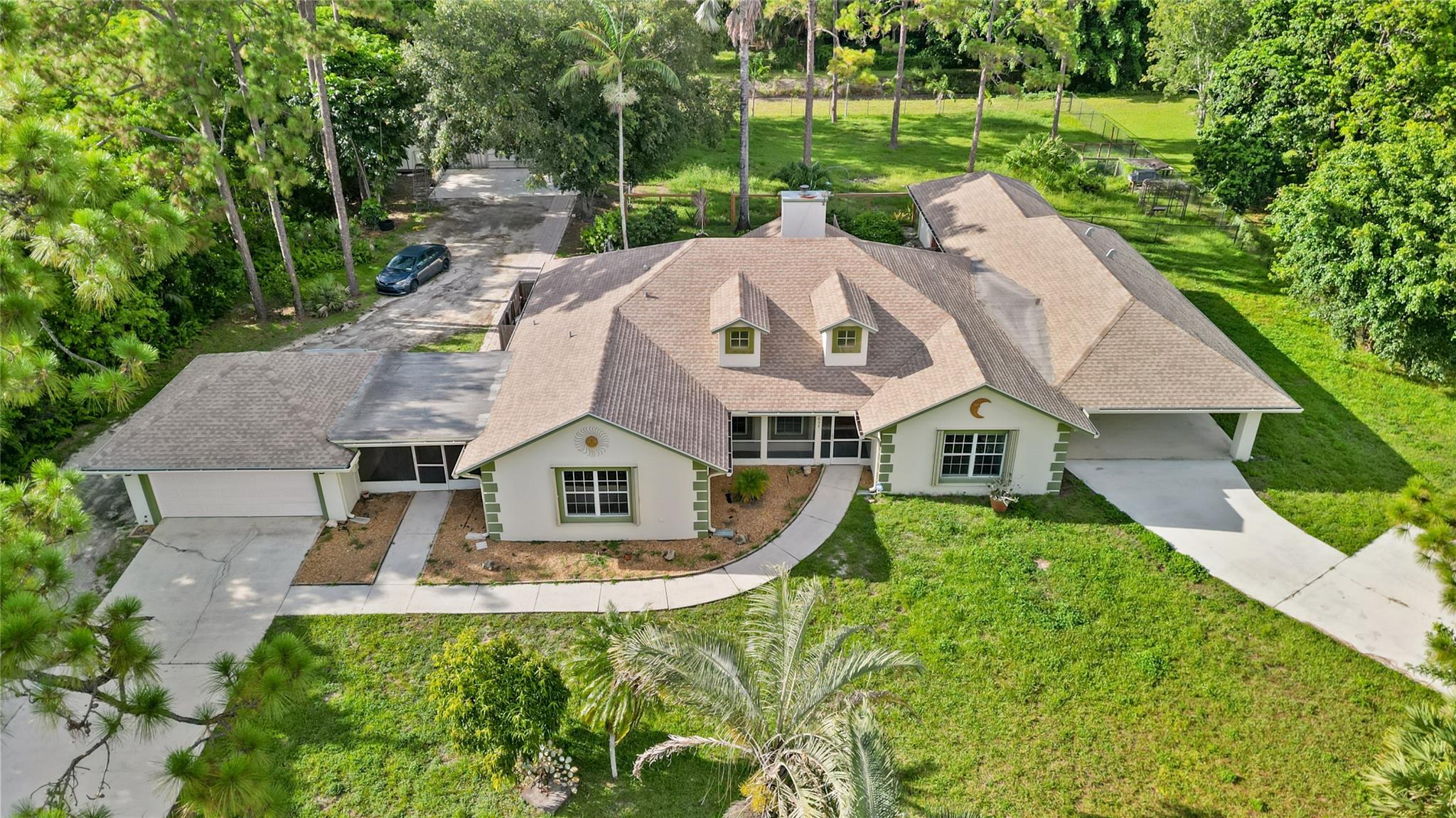 Discover your dream home! Best price per sqft in all of the The Acerages. This charming property has it all, including a 1256 sq ft ADA-compliant guest house built in 2019, with a full kitchen, laundry room, roll-in shower, impact windows, a private patio, and a 2-car carport. With this 6 bedroom home you will never run out of space. The property also includes two extra storage sheds and a 1400 sq ft heavy-duty steel Quonset hut with electric, water, built-in shelving, and an office. Ideal for storing equipment, running a business, setting up a workshop, turning into a barn, or storing all your toys. This contemporary pool home sits on 1.25 acres, fully fenced with multiple screened and unscreened patios and 2 car attached garage.