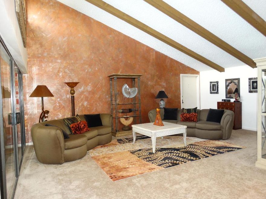 Well maintained, huge 3/2 corner condo with extra windows, vaulted ceilings, wood beams and a glass enclosed patio.  The home is being offered furnished and has large walk in closets, a full size washer/dryer in unit, newer a/c, hot water heater, appliances, carpet and new roof in 2012.  This is a beautiful community with a secured building entrance, covered assigned parking and storage all  in a great central Boca location in desirable Boca Del Mar! HOA fee includes cable, water, pool  and a clubhouse.