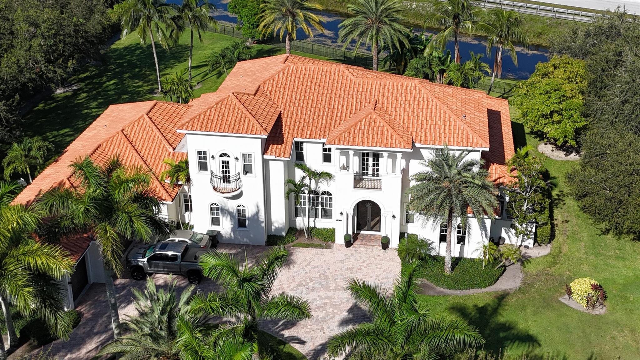 Experience unparalleled luxury in this 6,823-sq-ft under air, gated estate on 1.16 acres in Wellington's prestigious Aero Club private air park community. Boasting 6 bedrooms, 6.1 baths, open plan kitchen with a gym/media room, office, butler's kitchen, and staff/in-law apartment, this clever layout offers privacy and elegance. The main kitchen, with gas range, wine cellar, and a choice several large entertainment spaces, is a chef's dream. Enjoy sunset views from the deep patio and west-facing pool with resurfaced decking. With no neighbors to the north and a pocket park next door, this estate is private and opulent. Many features include 3-car garage, impact glass throughout, keypad entry. Just 1 mile by golf cart to WEF. Aviation perks include 4,000-ft paved runway and tie down.