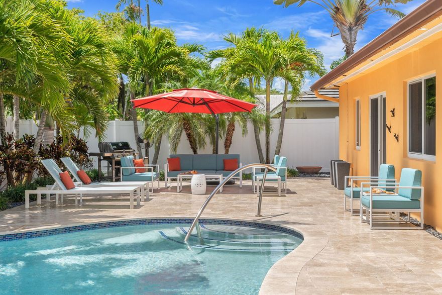 Discover this stunning single-family home in the gated community of Jenada Isle. A welcoming courtyard entry w/a tranquil waterfall sets the tone for this private retreat. Newly renovated, state-of-the-art kitchen is truly a chef's dream—featuring dual refrigerators, an induction cooktop, & a movable island designed for both style & functionality. Four spacious bedrooms in a desirable split floor plan, along w/2 full baths that provide comfort for family & guests. Step outside to your beautifully updated outdoor oasis, complete w/a sparkling pool, jacuzzi, & expansive patio—perfect for entertaining or relaxing. Recent upgrades include new insulation (2024), a new interior electrical panel, water heater, HVAC system, & a well for irrigation & flat roof (2026). This home truly has it all.