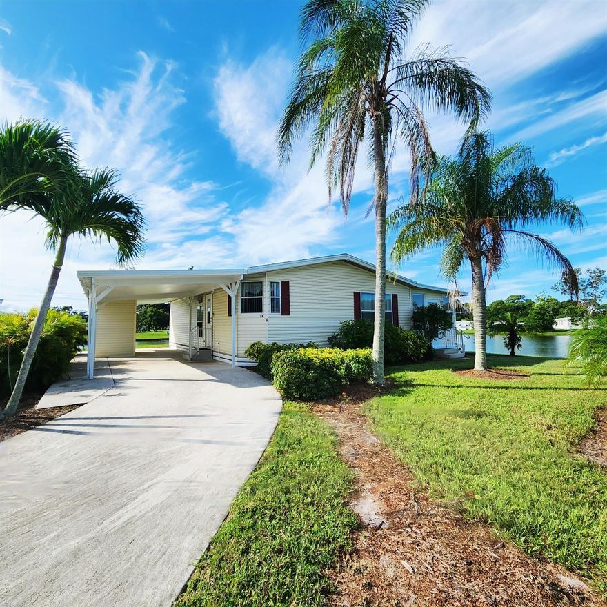 Natural beauty surrounds this 2bed/2bath home, nestled in the back of a CulDeSac on a large corner lot w/ panoramic lake views.Watch ducks & wildlife glide across water & colorful evening sunsets in large window/screened in Florida Rm. Expansive lot offers privacy & space, great for pets, gardening, grilling, entertaining, or soaking in peaceful surroundings. Recent updates include a 2020 roof, 2023 AC & 2022 carpet/flooring, WaterHtr 2020. PRIME LOCATION; near beach, grocery stores, post office, banks, hospitals, pharmacy & more! Lot rent of 1080.98 includes private golf course (no fees to play) heated pool, fitness, pickleball, tennis, shuffleboard, bocce, gym, library, card games, MahJong, Bible study, wood workshop, parades, dinners, dances, trips & more! Lawn cutting & trash included