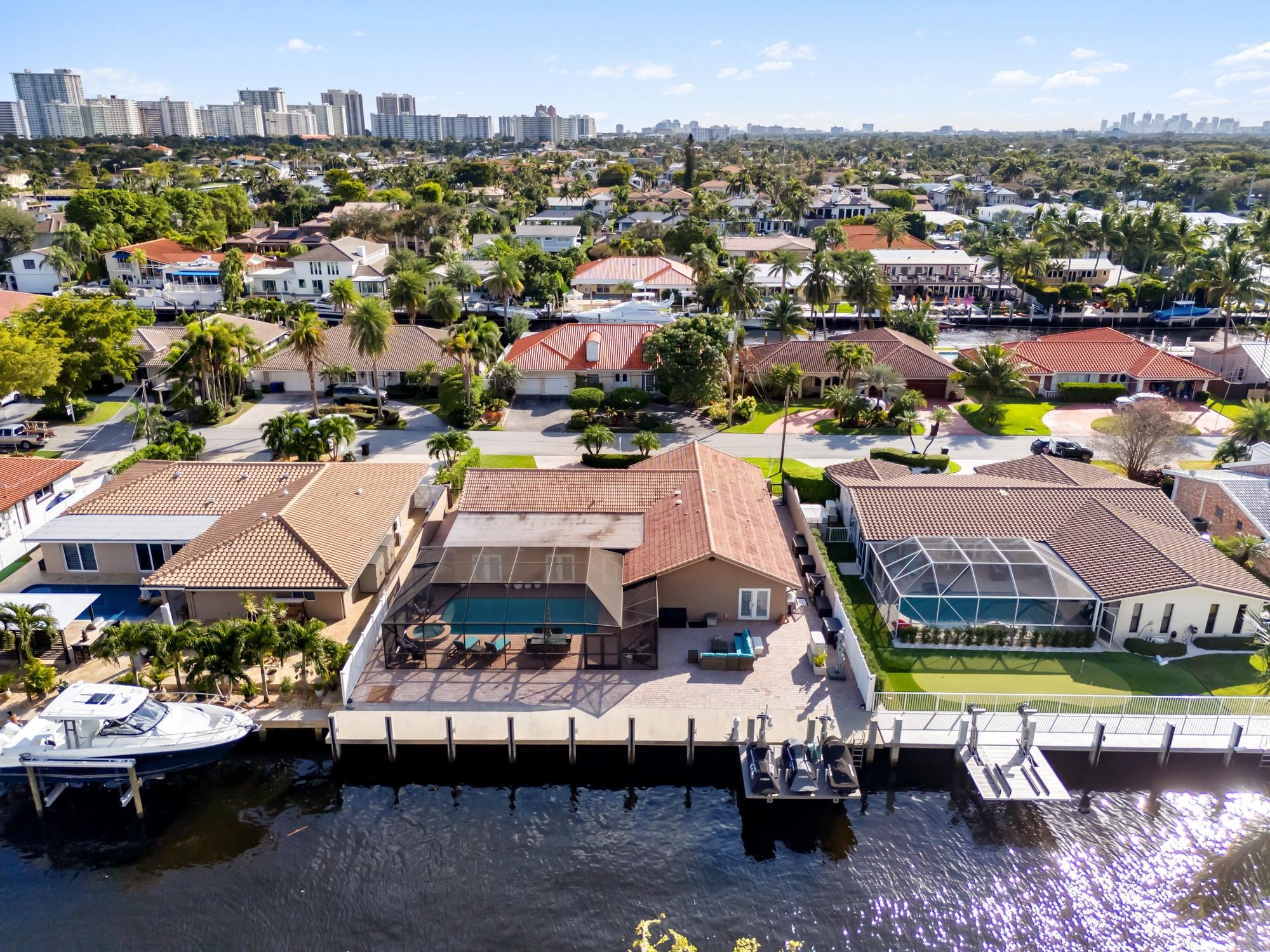 Discover the essence of luxury living in this impeccably updated home in Coral Ridge. Just moments from the beach, dining & shopping, this waterfront gem offers 85 ft of ocean-access frontage with no fixed bridges. The property boasts a new seawall, concrete dock, and 3-jet ski lift. Unwind in the screen-enclosed saltwater pool and spa overlooking tranquil canal views. Inside, enjoy vaulted ceilings, marble floors, impact windows & doors, and a smartly designed split plan. The chef’s kitchen features double ovens, dual dishwashers, a gas range, wine cooler & a backup generator. The master suite includes a marble shower, jacuzzi tub, dual vanities, and generous his-and-hers closets. Perfectly located near Pine Crest School, Cardinal Gibbons & St. Mark’s, this home epitomizes refined living.