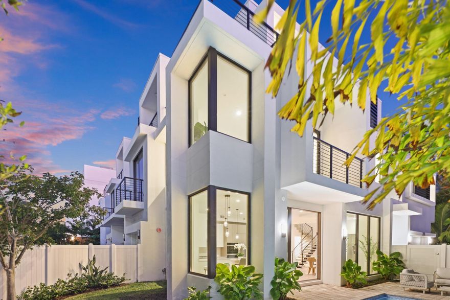 Just completed and move-in ready, this spectacular corner luxury townhome offers an exceptional opportunity to live in the very heart of downtown Delray Beach. Ideally situated just two blocks from iconic Atlantic Avenue, everything is at your fingertips -- from award-winning restaurants and charming boutiques to vibrant nightlife and the area's pristine sandy beaches. This newly staged home is effortless coastal living at its finest.
Architecturally distinctive and thoughtfully designed, this brand-new residence features four spacious bedrooms, four full bathrooms, a powder room, a versatile club room with wet bar, and a spectacular rooftop terrace designed for unforgettable evenings under the stars. Whether hosting sunset cocktails or enjoying a quiet night with friends, the rooftop retreat elevates the lifestyle experience.
Designed by renowned architect Shane Ames of Ames International Architecture, the home showcases modern elegance paired with everyday functionality. A dramatic windowed elevator services all three levels, adding both convenience and architectural interest. Soaring ceilings, expansive impact glass, and abundant natural light create an airy, open ambiance throughout. The chef's kitchen is a true showpiece, complete with an oversized island, gas cooktop, premium Miele appliances, and extensive custom cabinetry -- seamlessly flowing into generous living and dining spaces ideal for entertaining.
Outdoors, a private heated pool with tranquil water feature offers a rare resort-style escape in the middle of downtown. The two-car garage -- with ceiling height suitable for car lifts -- plus a separate golf cart garage provide exceptional flexibility for car enthusiasts and beach cruisers alike. The home is also pre-wired for electric vehicle charging and advanced smart home systems, including lighting and electric shades, delivering modern convenience at every turn.
Upstairs, the luxurious primary suite serves as a serene sanctuary, featuring two walk-in closets, a comfortable sitting area, and a spa-inspired bath designed for relaxation. Additional highlights include a skylight that enhances natural brightness, a well-appointed laundry room with side-by-side washer and dryer, and abundant storage throughout.
This home in the heart of Delray Beach truly has it all.