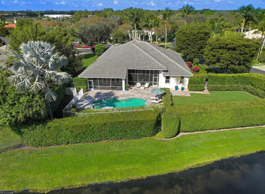 Stunning corner lot in The Equestrian Club Estates. Experience the ultimate in equestrian living. Exceptional 3bedroom/3.1bathroom with 3 car garage. Situated on approximately 0.6 acres just steps away from the Palm Beach International Equestrian Center.The grand entrance features a picturesque circular driveway, setting the tone for the beautiful gardens and lush landscaping that surround the property. Inside, discover a split floor plan with a private master wing, complete with his and hers closets, dual sinks, and a luxurious dual-entry shower. Two additional bedrooms and two bathrooms are tucked away in a separate wing, perfect for guests or family members.Enjoy the high-quality finishes, including marble and wood flooring, a wood-paneled