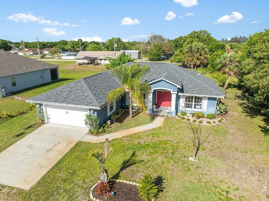 Prepare to be charmed by this Vero Lake Estates gem perfectly positioned on a spacious .31-acre fully fenced lot (100x134) with room for your boat, RV, and all your toys and no HOA to limit your lifestyle.  Built in 2003 with solid CBS construction, this 3 bedroom, 2 bath, 2 car garage home offers 1,724 sq ft of thoughtfully designed living space with a desirable split floor plan. Step inside to soaring ceilings, abundant natural light, and updated laminate and tile flooring that flow seamlessly throughout. The living area features custom wood accent walls, adding warmth, character, and a designer touch you won't find in new builds.  The kitchen is both functional and inviting with a Samsung appliance suite, ample cabinetry, and a pass-through bar window perfect for entertaining. Enjoy casual meals in the kitchen dining area with French doors that open directly to your oversized screened patio. Or in your formal dining space off the living room.   The true highlight is the indoor-outdoor lifestyle this home delivers. A 3-panel pocket sliding glass door opens fully to an expansive screened lanai, creating seamless flow for gatherings. Outside, unwind in your private fenced in backyard oasis complete with banana trees, zoned irrigation system, a custom stock tank pool with new deck, and plenty of space for gardening or pets.  The primary suite is a peaceful retreat featuring patio access, an updated vanity, garden tub, and separate walk-in shower. Guest bath has also been refreshed with updated finishes.  Major updates provide peace of mind, including: New Roof (2024), Water Heater (2023), Reverse Osmosis System (2023), New Well Pump (2025), Water Softener (newer).   Additional highlights include a large laundry room with extra storage, charming front entry with non-slip tile patio, and a property that truly embraces the Florida lifestyle space, privacy, and flexibility.  Located in highly desirable Vero Lake Estates, known for its oversized lots, freedom, and growing new construction market this home offers incredible value and opportunity. Priced to sell schedule your showing before it's gone. Home being sold AS-IS.
