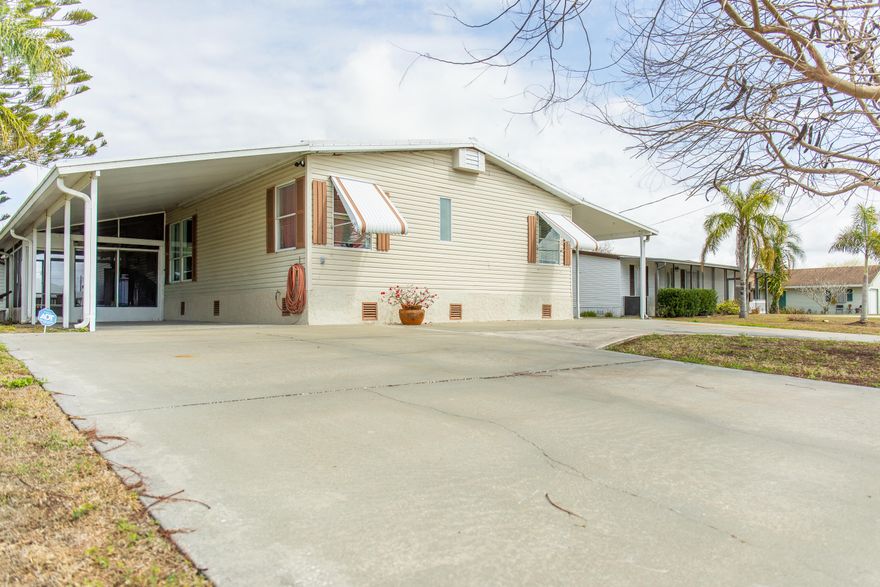 Taylor Creek Isles- Lake Okeechobee Access  3 Bedroom / 2 Bath Manufactured Home with spacious Florida room, updated laminate flooring throughout, a large kitchen island and master suite with en-suite. Enjoy outdoor living with two screened rooms, two carports, an insulated workshop, a boat house, a dock with a hoist-perfect for boating and fishing lovers.