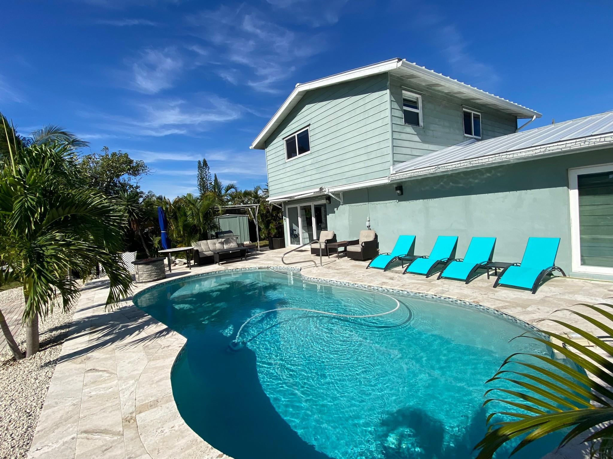 Bring your boat, there is 50 feet of dockage available in this furnished 2/2 house rental. No fixed bridges. Marina is close by. Close to downtown and the beaches, this home is two stories. Newer flooring and updated kitchen. The home also has an updated diamond bright heated pool with saltwater system. Convenient to everything and excellent where you can easily turn your vessel. Mirror polished floors on ground level and three large TV's. High style furniture with living room sofa bed. Bedrooms equipped with writing desks. Metal Roof. Great opportunity.