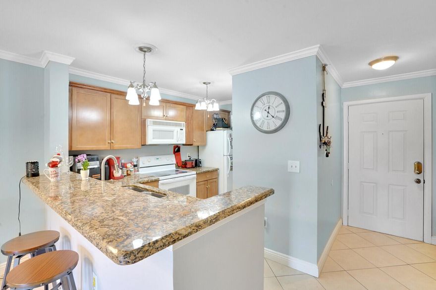 Welcome to this inviting first-floor condo in a gated community, ready for a new owner. Ideal as a first home, a downsize, or an investment with immediate rental allowed. The open layout features diagonal tile and laminate flooring, crown molding, and a kitchen with granite countertops, breakfast bar, and stackable washer/dryer. The primary suite offers a walk-in closet with built-ins, and the screened patio provides a private outdoor space. Pet-friendly with no weight limits (breed restrictions apply). AC 2020.
