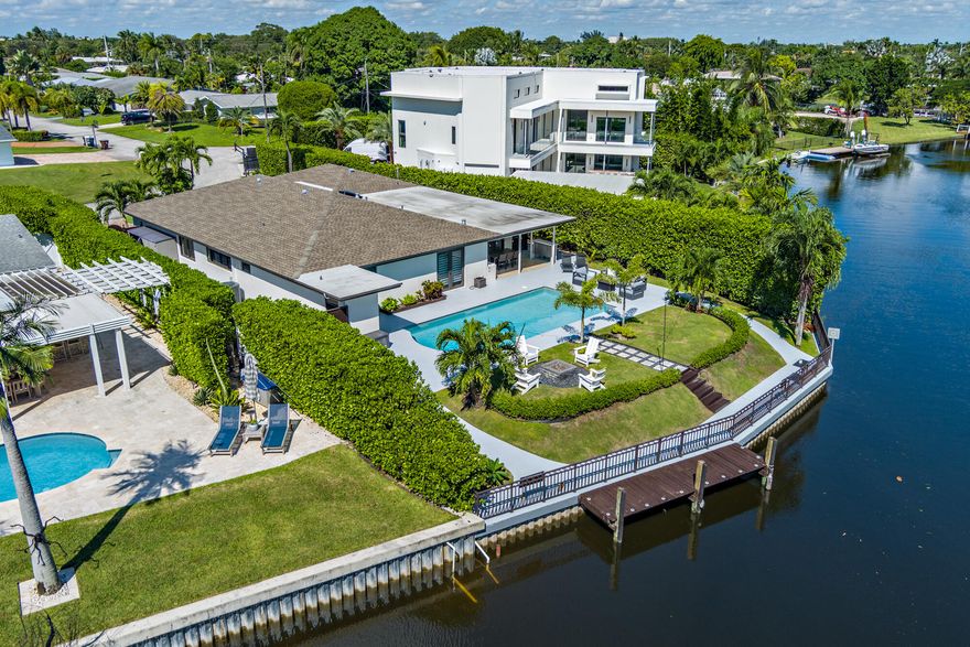 One-of-a-Kind Waterfront Retreat in Lake Clarke Shores — Fully Renovated (March 2026) Discover the perfect blend of privacy, comfort, and South Florida living in this beautifully upgraded 4-bedroom, 3-bathroom pool home with a 2-car garage, ideally positioned on a unique canal-front lot in the highly sought-after community of Lake Clarke Shores. No detail was overlooked in the recent renovations, completed in March 2026. The stunning kitchen features custom-made soft-close European cabinetry, exquisite backlit natural Cristallo stone, and an oversized island designed for entertaining. Both the primary and guest bathrooms have been completely redesigned with modern, high-end finishes. Step outside into your private waterfront oasis. The backyard showcases brand-new shell stone pavers and a  fully equipped outdoor kitchen with natural gas, highlighted by a striking backlit Cristallo feature behind the grill—perfect for evening gatherings. Pool has also been fully renovated.  Tucked away on a quiet, low-traffic street, this home offers a serene and private setting. Enjoy peaceful canal views with a seawall and private dock, ideal for relaxing, entertaining, or taking in breathtaking sunsets. Additional features include: • A large, recently renovated swimming pool • Newer roof • Two spacious living areas for added flexibility • 10,200 sq ft lot • 3,268 total sq ft. Lake Clarke Shores is known for its family-friendly atmosphere and strong sense of community, offering amenities such as pickleball, tennis, and basketball courts, parks, recreational spaces, and its own local police department for added peace of mind. Ideally located less than 10 minutes from PBI Airport, downtown West Palm Beach, CityPlace, and Palm Beach Island, this home combines convenience with tranquil waterfront living. Experience your own private waterfront paradise!