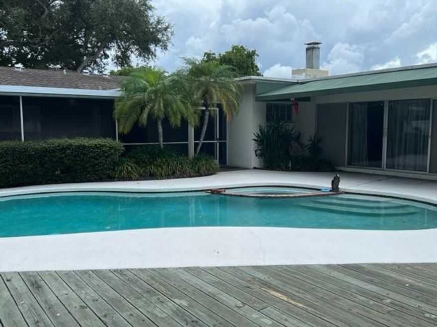 NO HOA! Spacious 5/3.5 with a Pool! Home has 4 bedrooms & 2.5 bathrooms inside main house, & a large 5th bedroom (or office, pool cabana,  guest room, gym) with a full bathroom alongside the pool. Remodeled kitchen has new cabinets, counters & stainless appliances. New porcelain tile thruout home. Freshly painted. Large family room has wood-burning fireplace. Spacious primary suite has a dressing area, dual closets & en suite bathroom. Sliding doors lead out to a rock garden that continues to a fully fenced pool & patio area. This home sits on an extra large lot, & the North side of the property is also fully fenced surrounding the green space area. Impact windows thruout. Roof 2010. A/C 2022. Water Heater 2015. Pool Pump 2018. Tankless water heater 2024 (5th bedroom). Electric panel 2024. There is a well used for the automatic sprinklers. Driveway is extra wide and has room for 4 cars. There is a large screened and covered patio that has a built-in outdoor kitchen, overlooking the pool.