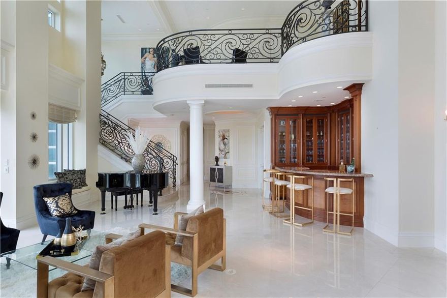 Vast miles-long views surround this lavish two-story penthouse atop Harbourage Place, soaring high over the sparkling Atlantic Ocean, winding Intracoastal Waterway and iconic coastline. Sprawling over 8,239± total sq. ft. with 5 bedrooms, 6½ baths and spectacular balconies, this estate-like abode exudes timeless, subtly glamorous style and is complete with yacht dockage at this prestigious luxury address. The 2-story window walled living space makes every social gathering a memorable occasion.