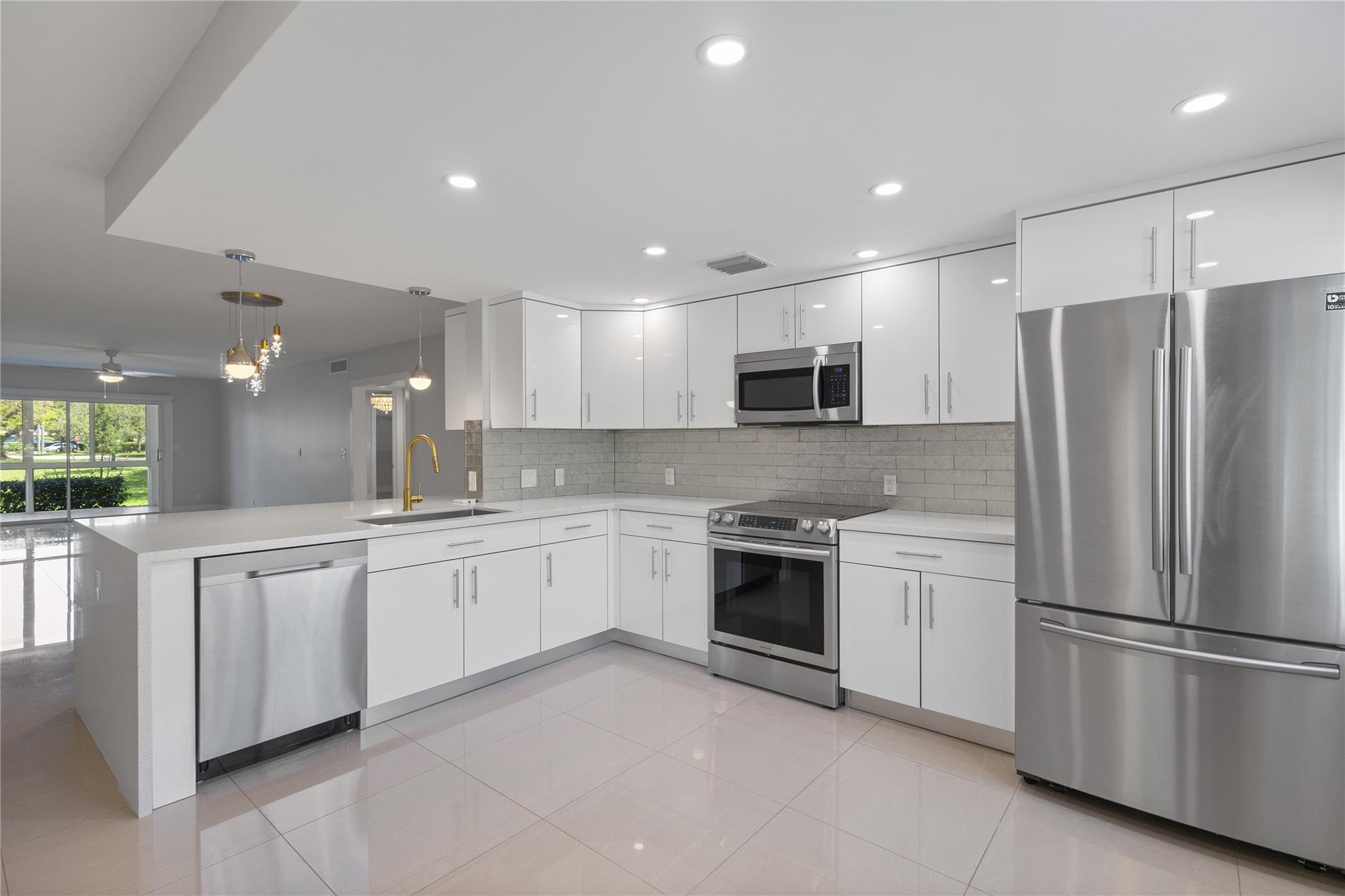 Large 2/2 corner unit on the first floor with a beautiful waterfront view! This unit is immaculate! All impact windows, doors and patio. Quartz waterfall countertop with Samsung appliances in the kitchen and ample cabinetry. Sparkling porcelain tile floors throughout living area. Automatic blinds/shades in the living room and primary bedroom. Incredible sunset views mirror the lake in the evening. Enjoy all amenities that Wynmoor offers. Unoccupied and easy to show.