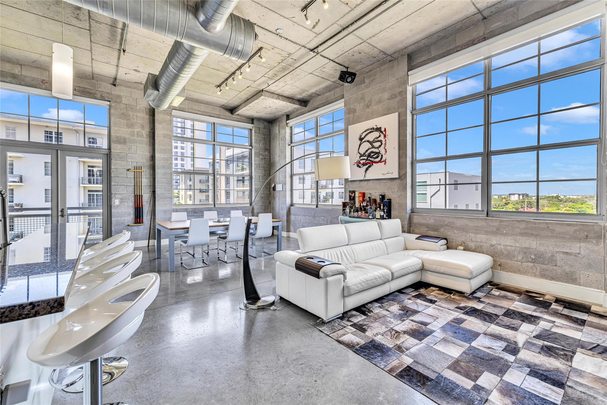 Tasteful Industrial Modern Loft - Light-Filled Corner Unit - Experience elevated loft living in this stylish and spacious Industrial Modern corner unit featuring soaring 13’ ceilings and an abundance of natural light. This 2-bed 2-bath residence includes a generous 2nd bedroom suite, polished concrete floors, impact windows and excellent storage. Large private balcony. Located just one block from the transformative new F.A.T. Village and only 2 blocks from Brightline, this is urban convenience at its best. Rooftop pool, gym, and BBQ area. Pet-friendly policy: 2 pets allowed, any size, no weight restrictions. Fully completed exterior and waterproofing project – paid in full. 2025 building and budget compliance. The perfect blend of style, space, and location. 1 garage space