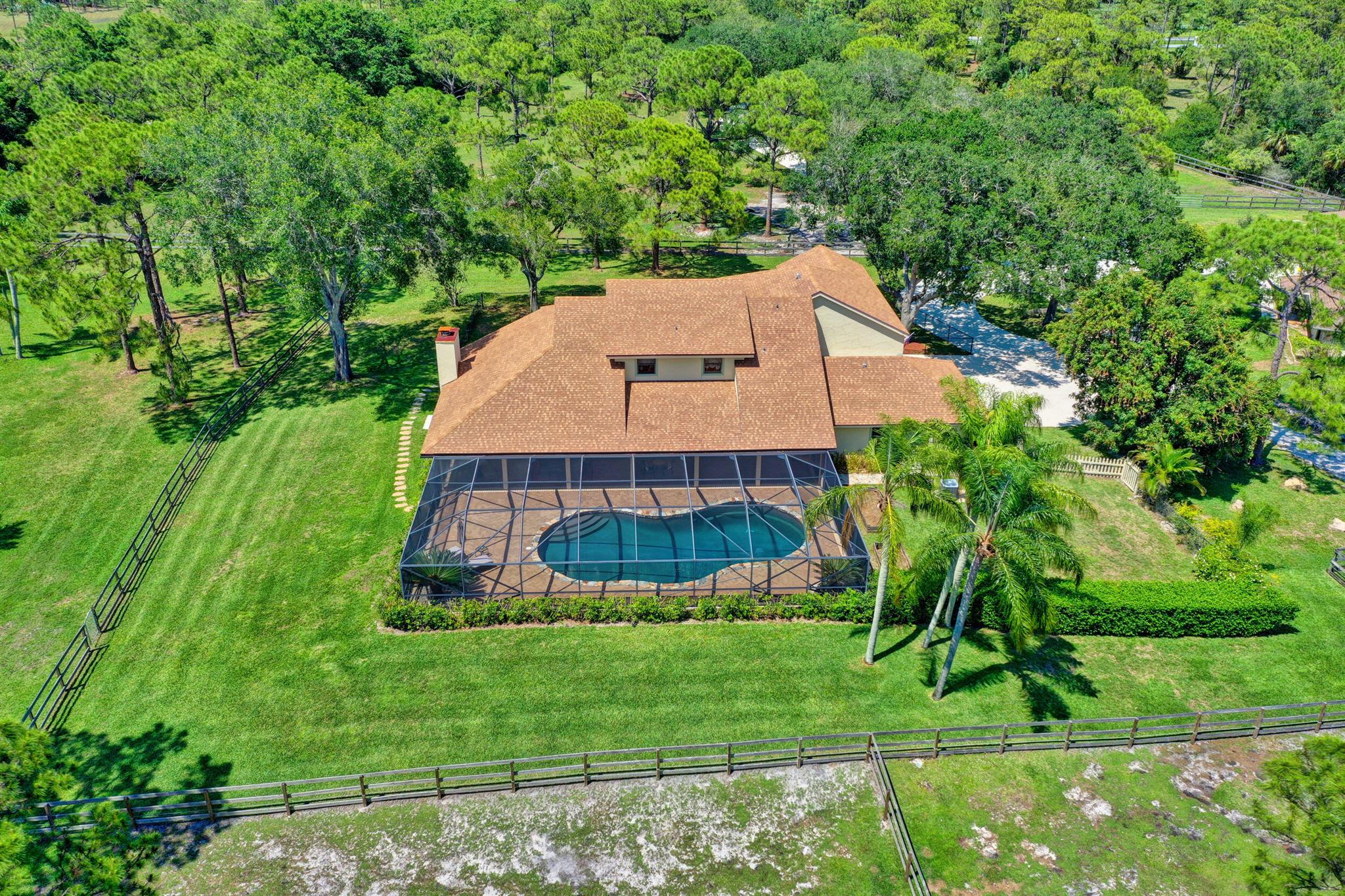 NOTE: The main house is offered for rent and is privately nestled on 20 acre estate. Stable manager/caretaker lives in guest house with her horses. 2 stalls and/or pasture board available. Spectacular ranch style estate offers 20 acres of land with no wetlands and backs up to preserve for tranquil views. Private entry with electronic gate leads you through the incredible tree-lined driveway to your expansive 5 bedroom, 6 bath, 3 car garage pool home. Tastefully furnished and decorated throughout, this unique homes offers detailed ceilings and hi-hats, stone fireplace and French doors leading out to your massive screened patio/pool. Gourmet kitchen with granite counter tops, separate island, an array of wood cabinets, stainless steel appliances with built-in wine refrigerator.